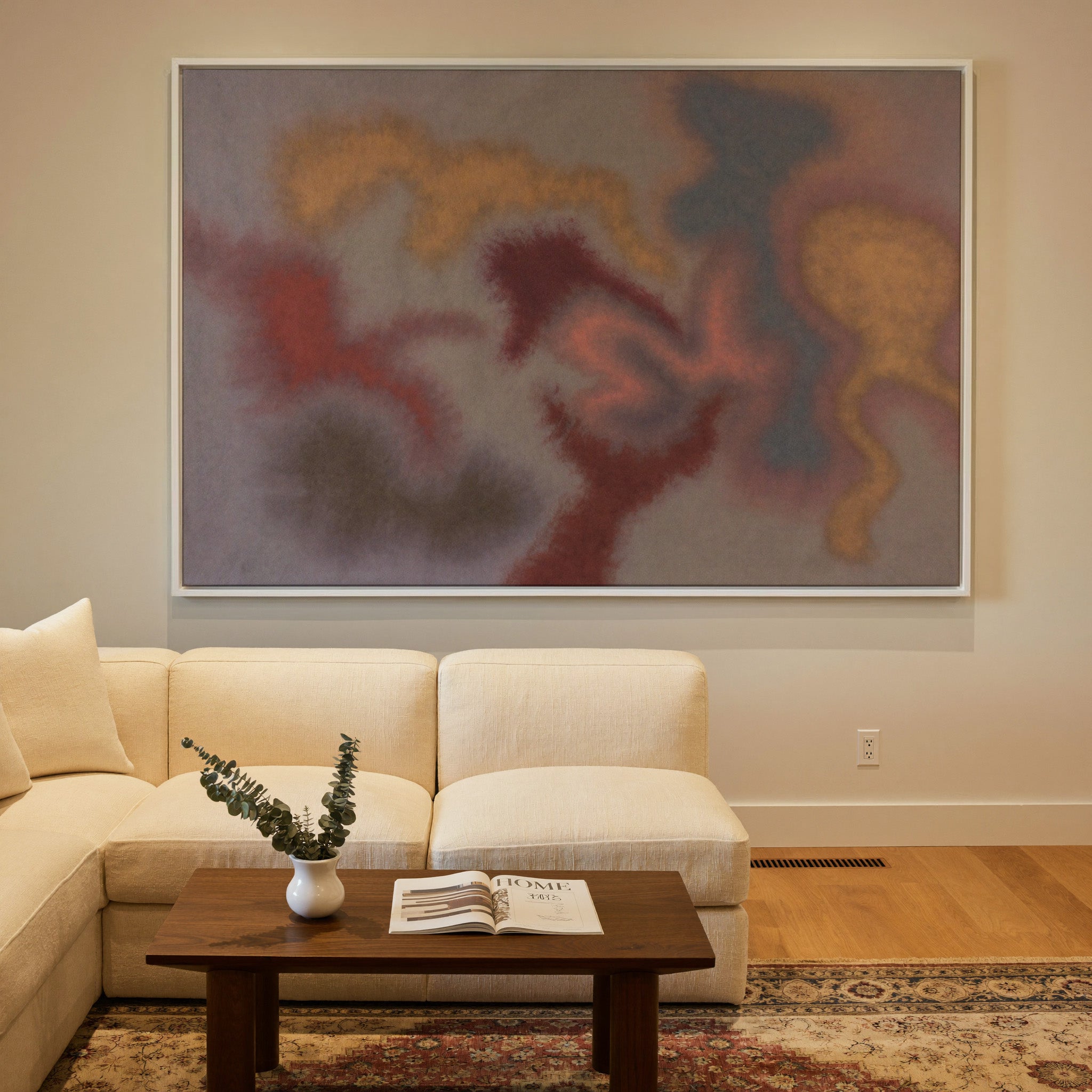 soft rust, gold, and slate abstract canvas wall art in a white frame in a styled room setting
