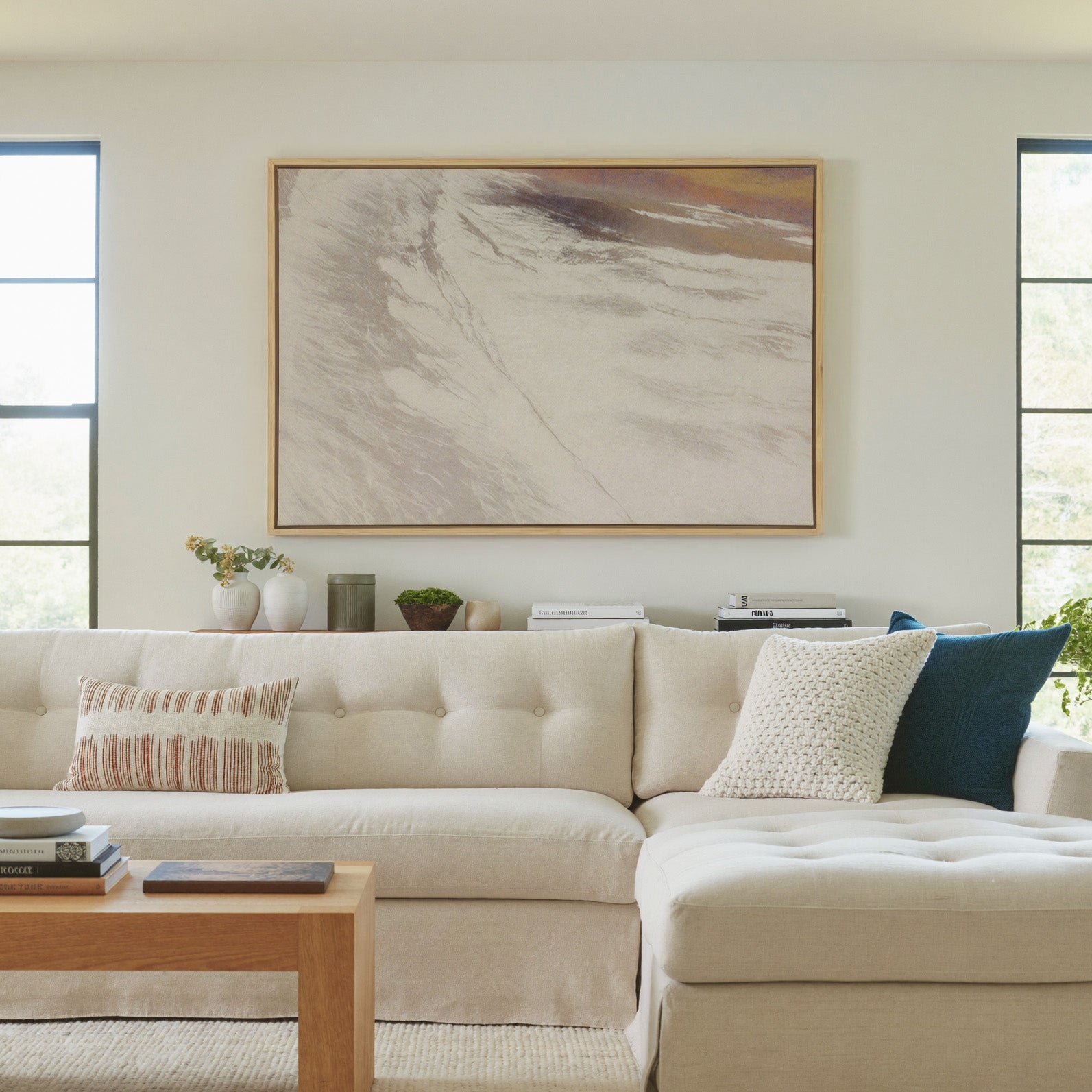 warm beige abstract with sweeping diagonal canvas wall art in a natural wood frame in a living room