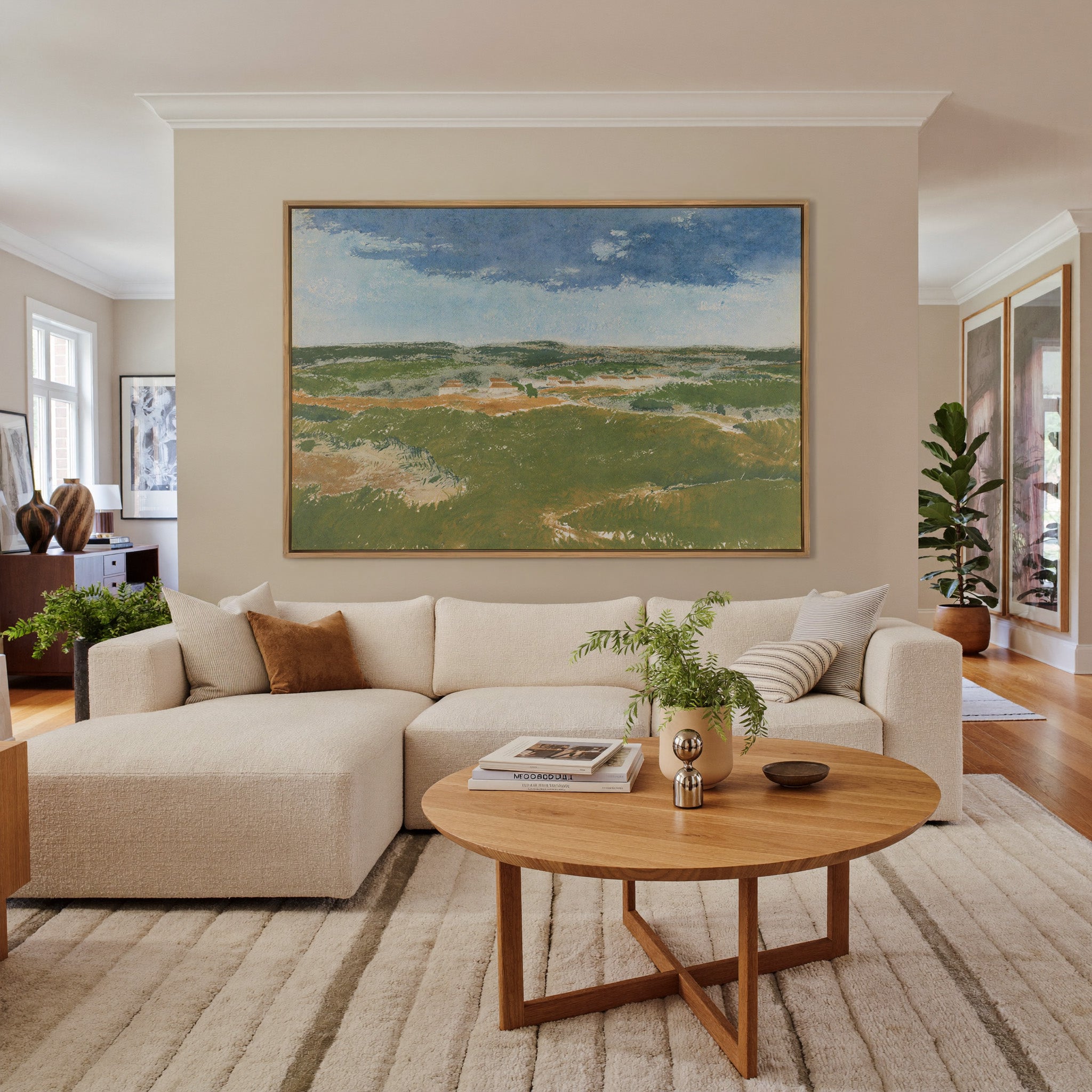 green dunes under a broad blue sky canvas wall art in an oak frame in a living room