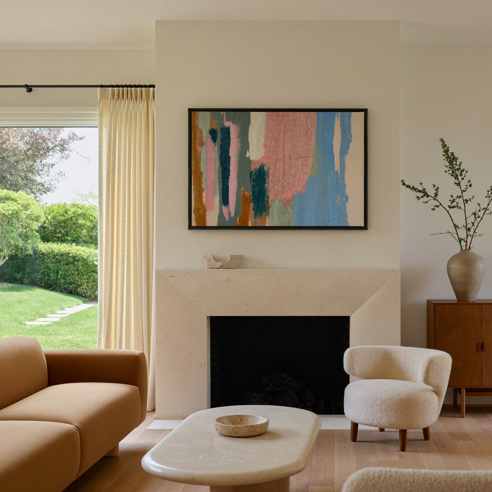 vertical abstract with pink, blue, teal, and canvas wall art in a black frame above a mantel