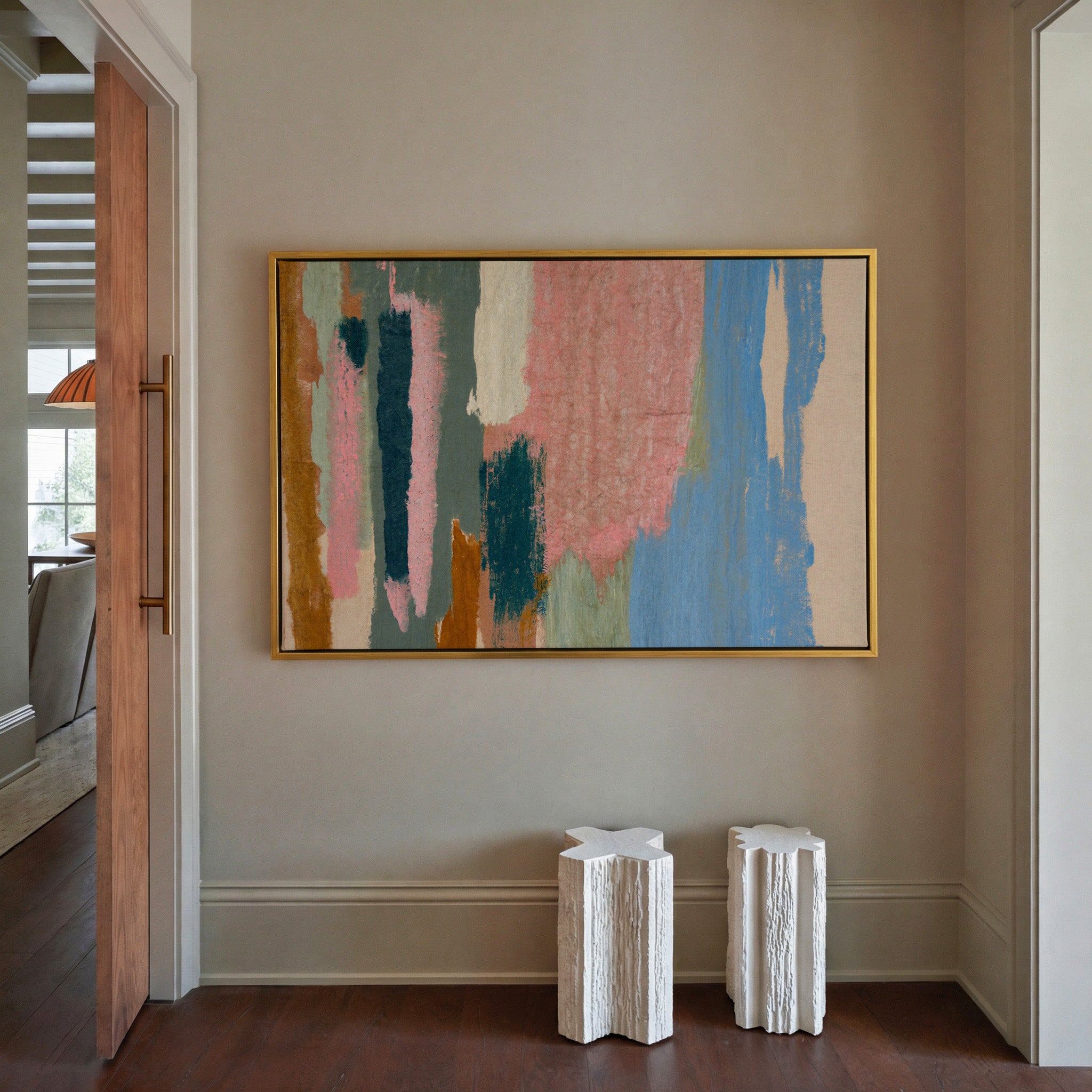 vertical abstract with pink, blue, teal, and canvas wall art in a gold frame in a styled room setting