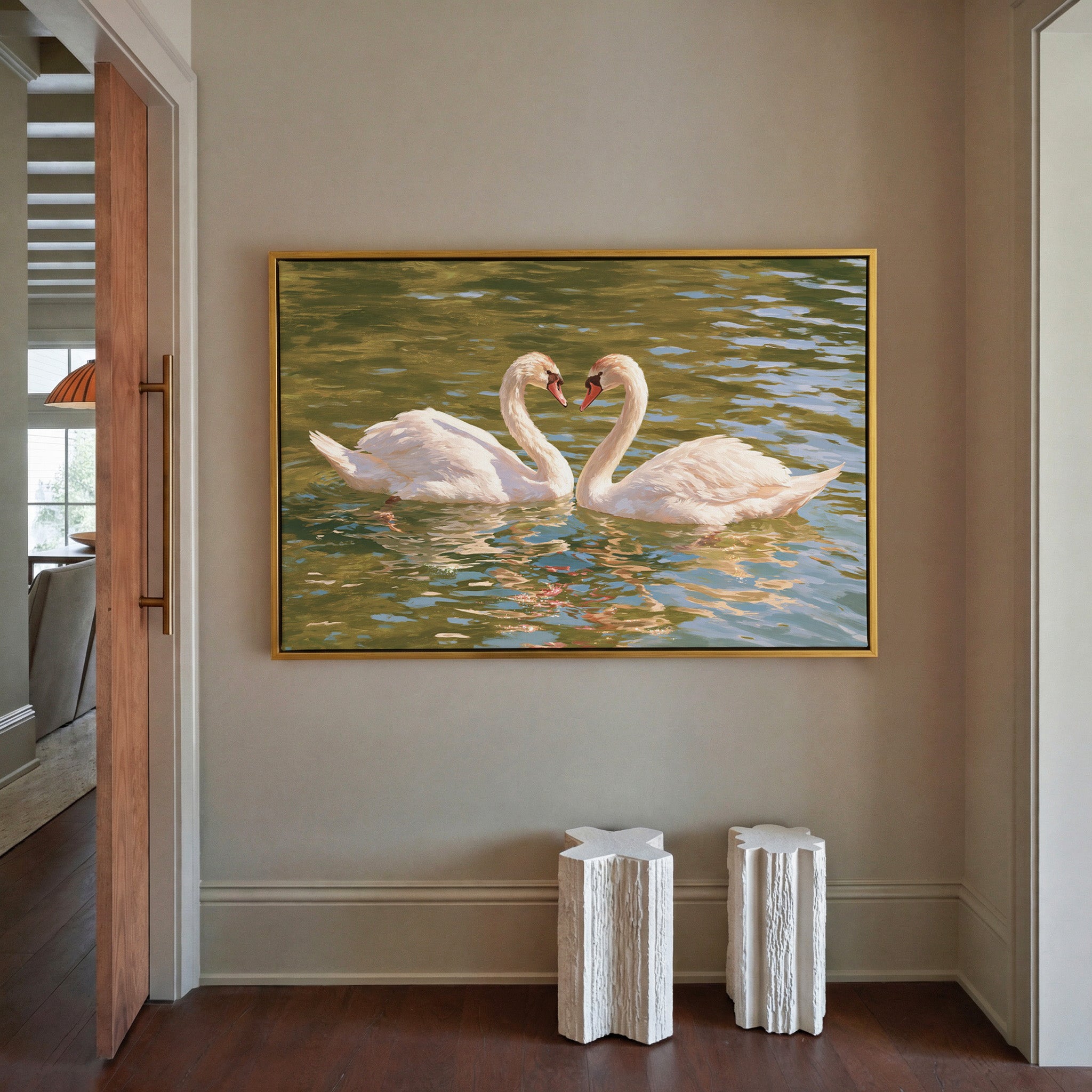 two white swans facing each other on green water canvas wall art in a gold frame in a styled room setting