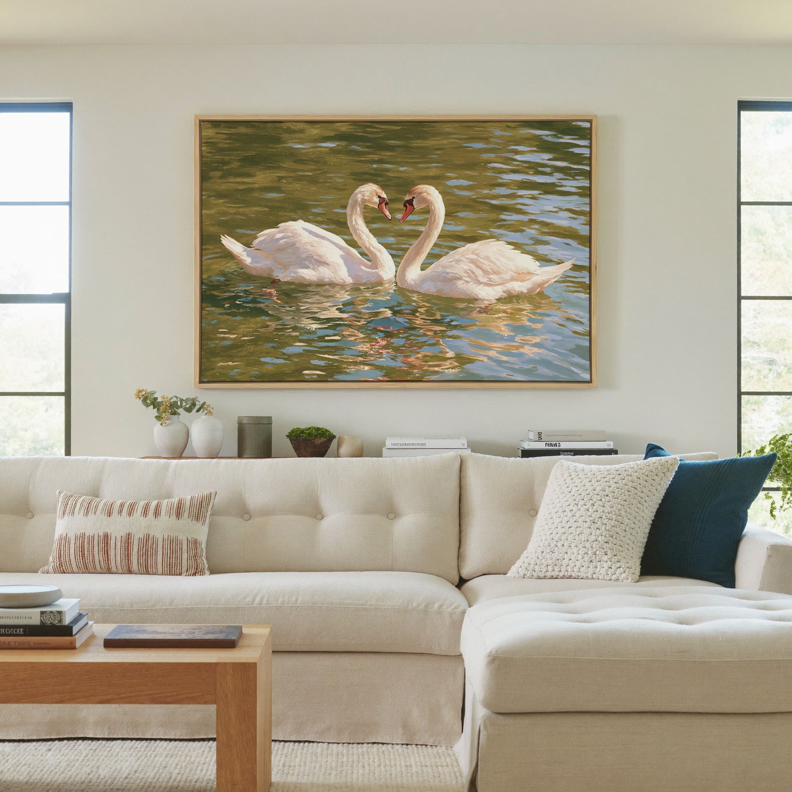 two white swans facing each other on green water canvas wall art in a natural wood frame in a living room