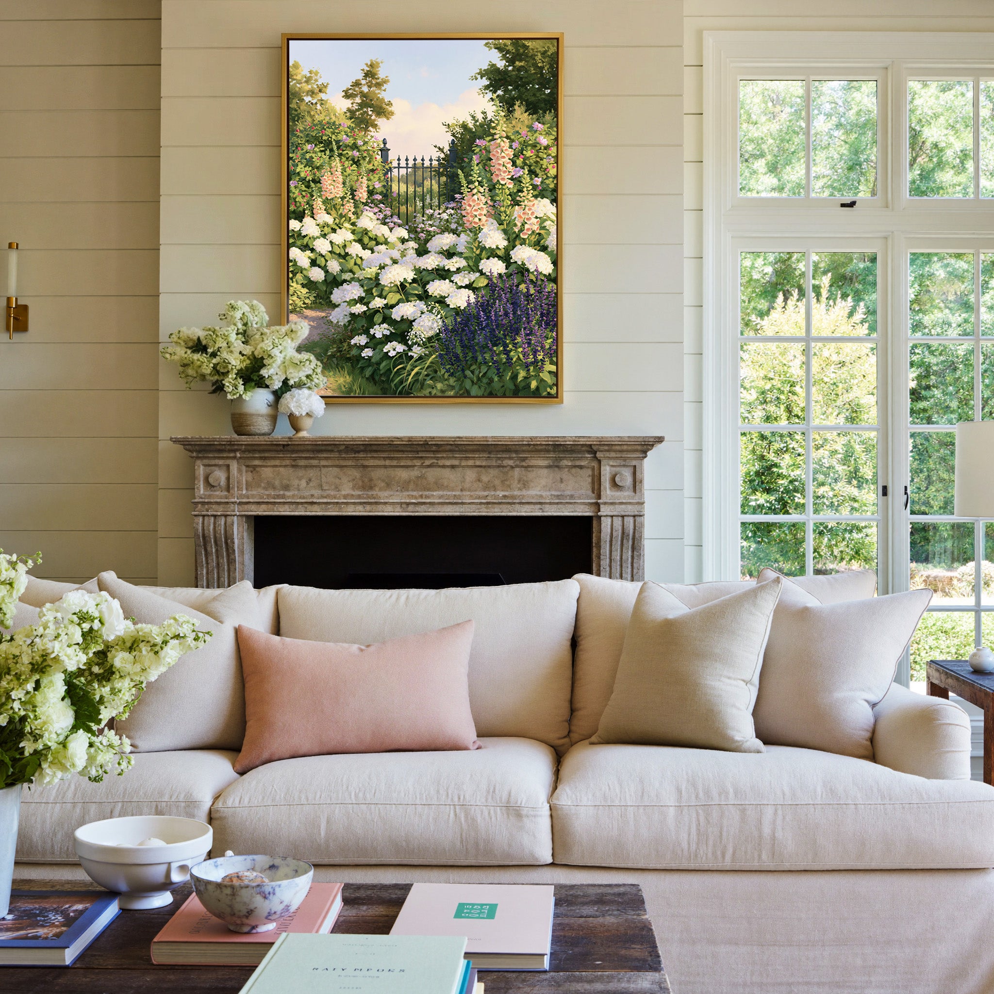 flower filled garden with iron gate and pastel canvas wall art in a gold frame above a mantel