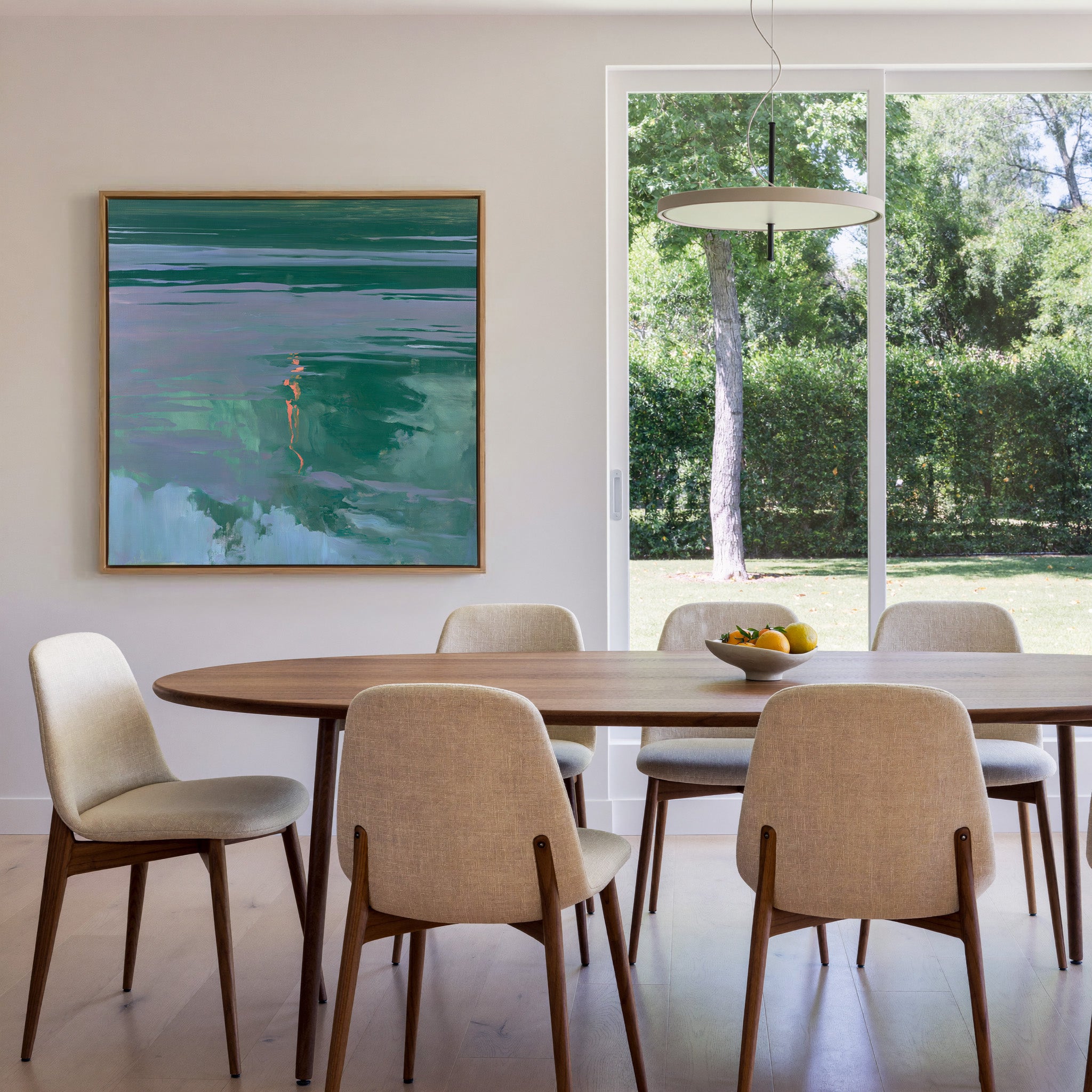 green and lavender abstract with coral canvas wall art in an oak frame in a dining room
