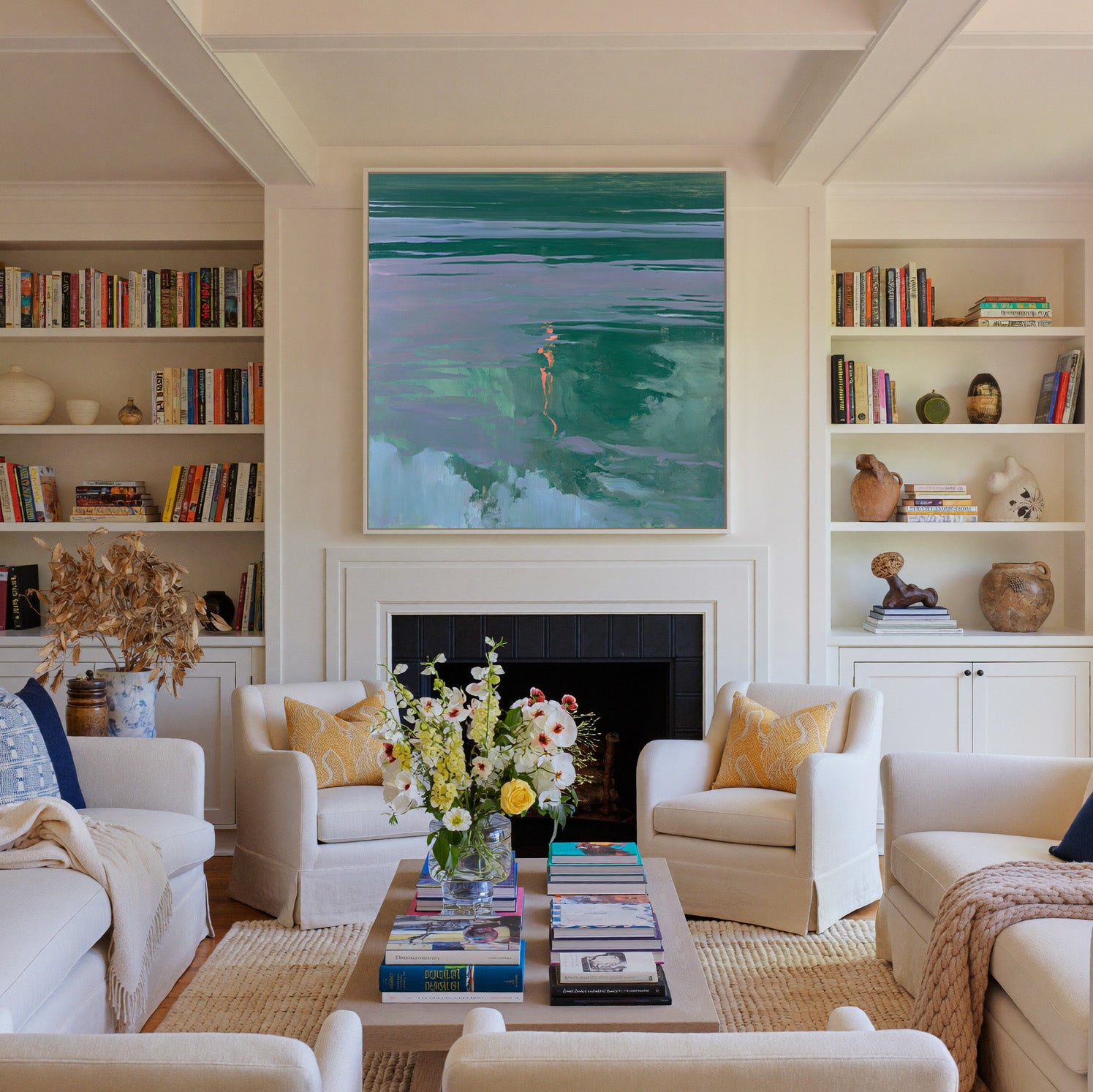 green and lavender abstract with coral canvas wall art in a white frame above a fireplace