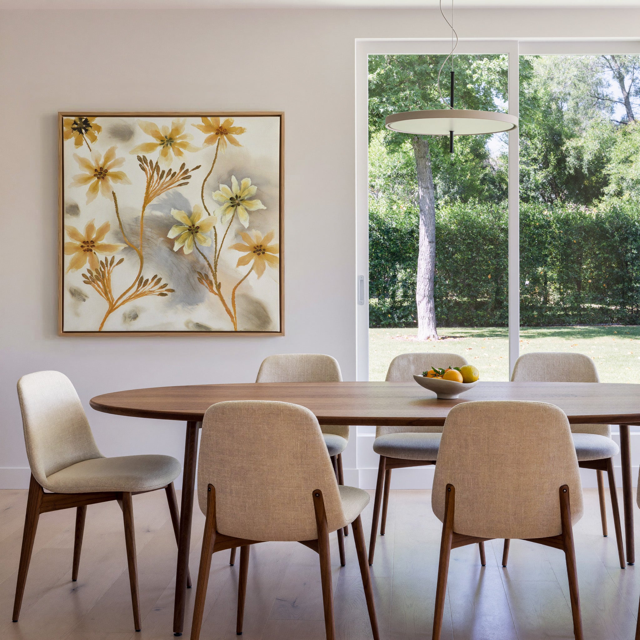 soft saffron and gray abstract floral forms canvas wall art in an oak frame in a dining room