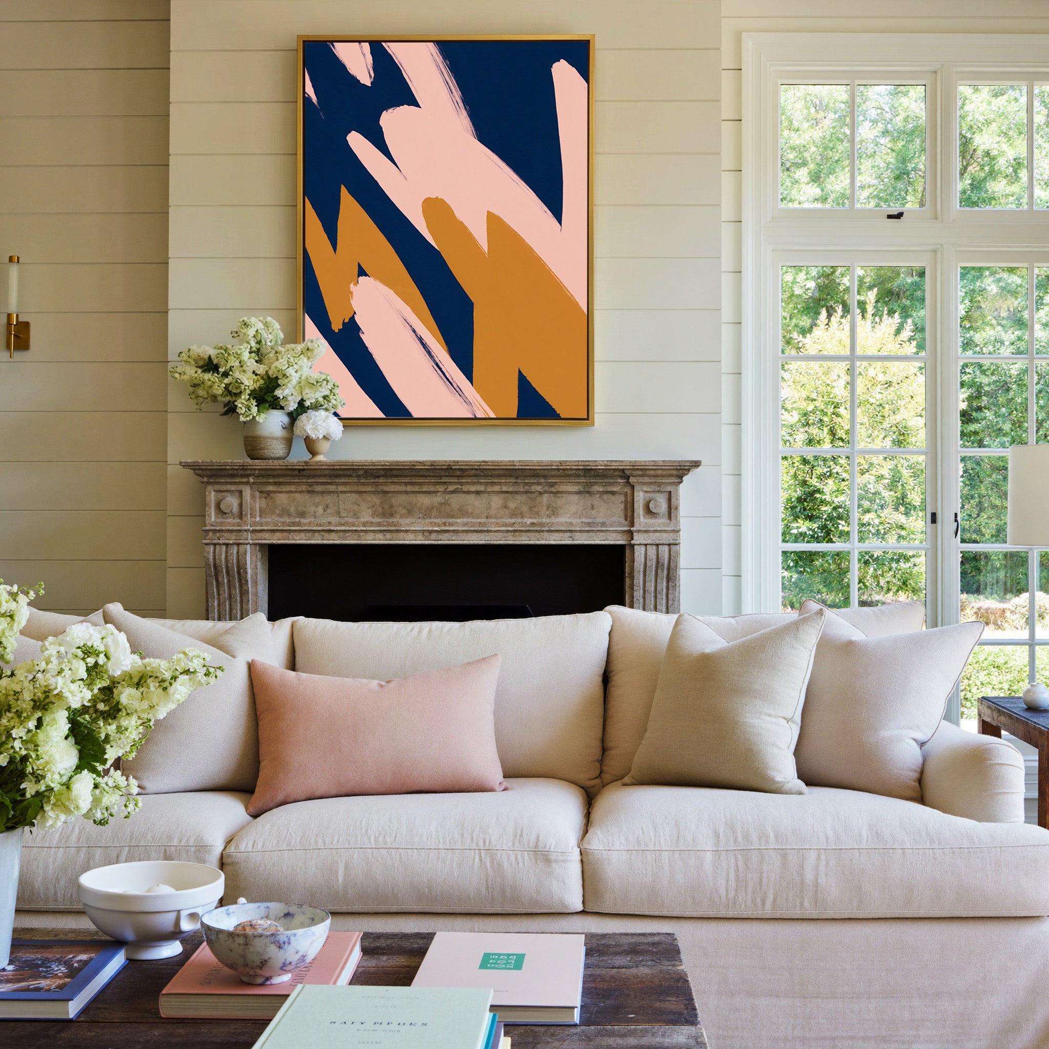 navy abstract with blush and ochre brush shapes canvas wall art in a gold frame above a mantel