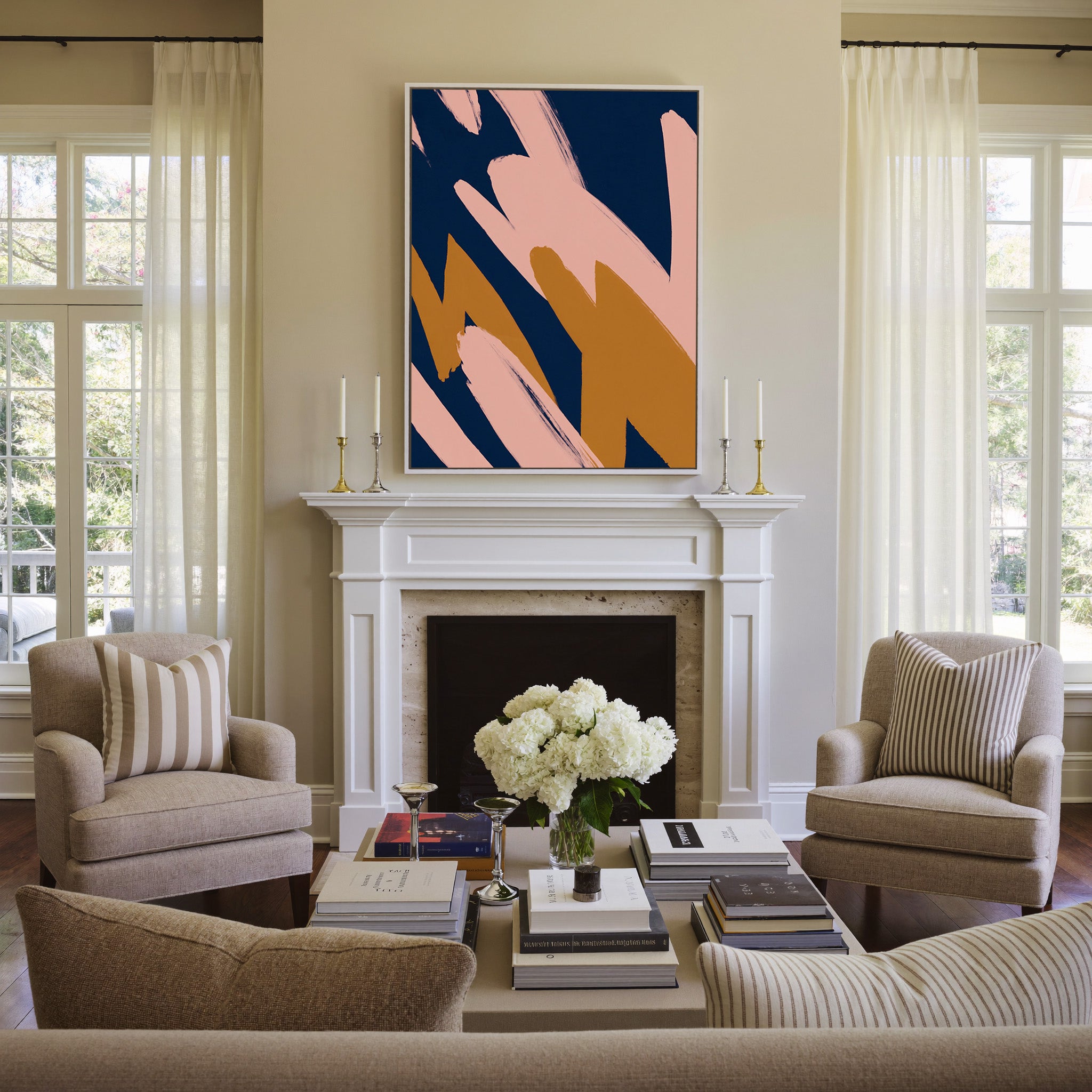 navy abstract with blush and ochre brush shapes canvas wall art in a white frame above a mantel