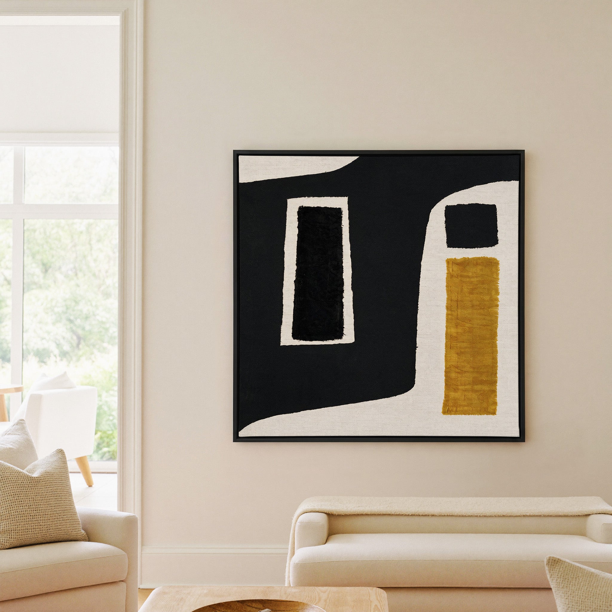 black and ochre abstract with framed blocks canvas wall art in a black frame in a living room