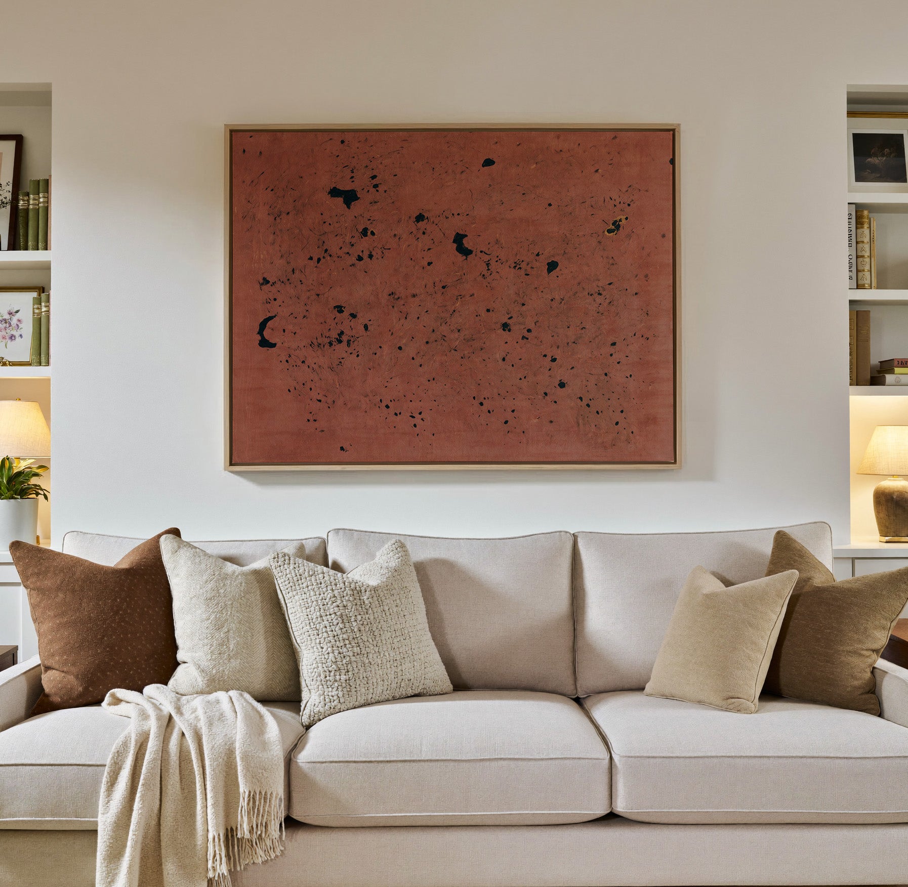 rust red abstract with scattered black marks canvas wall art in a natural wood frame in a styled room setting