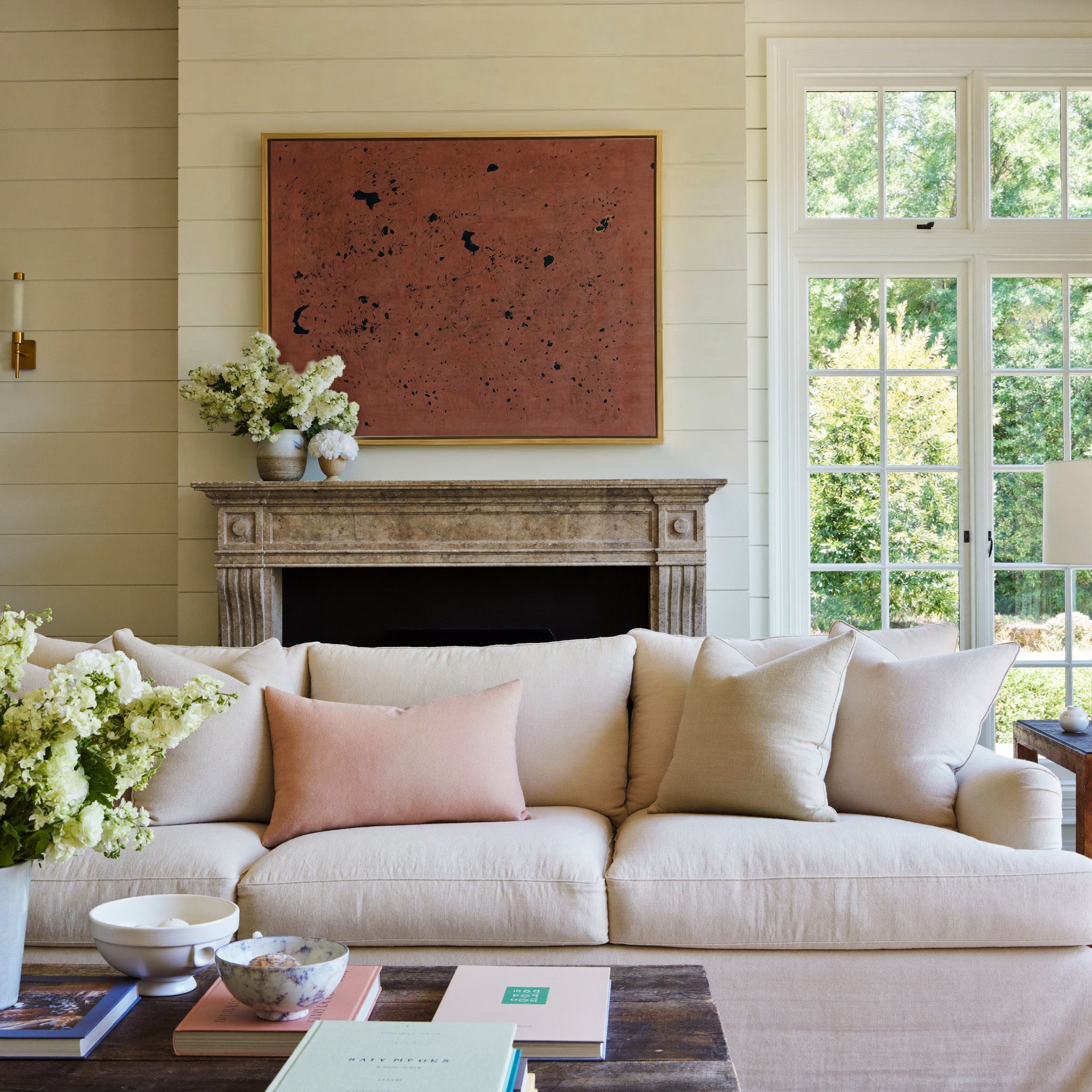 rust red abstract with scattered black marks canvas wall art in a gold frame above a mantel