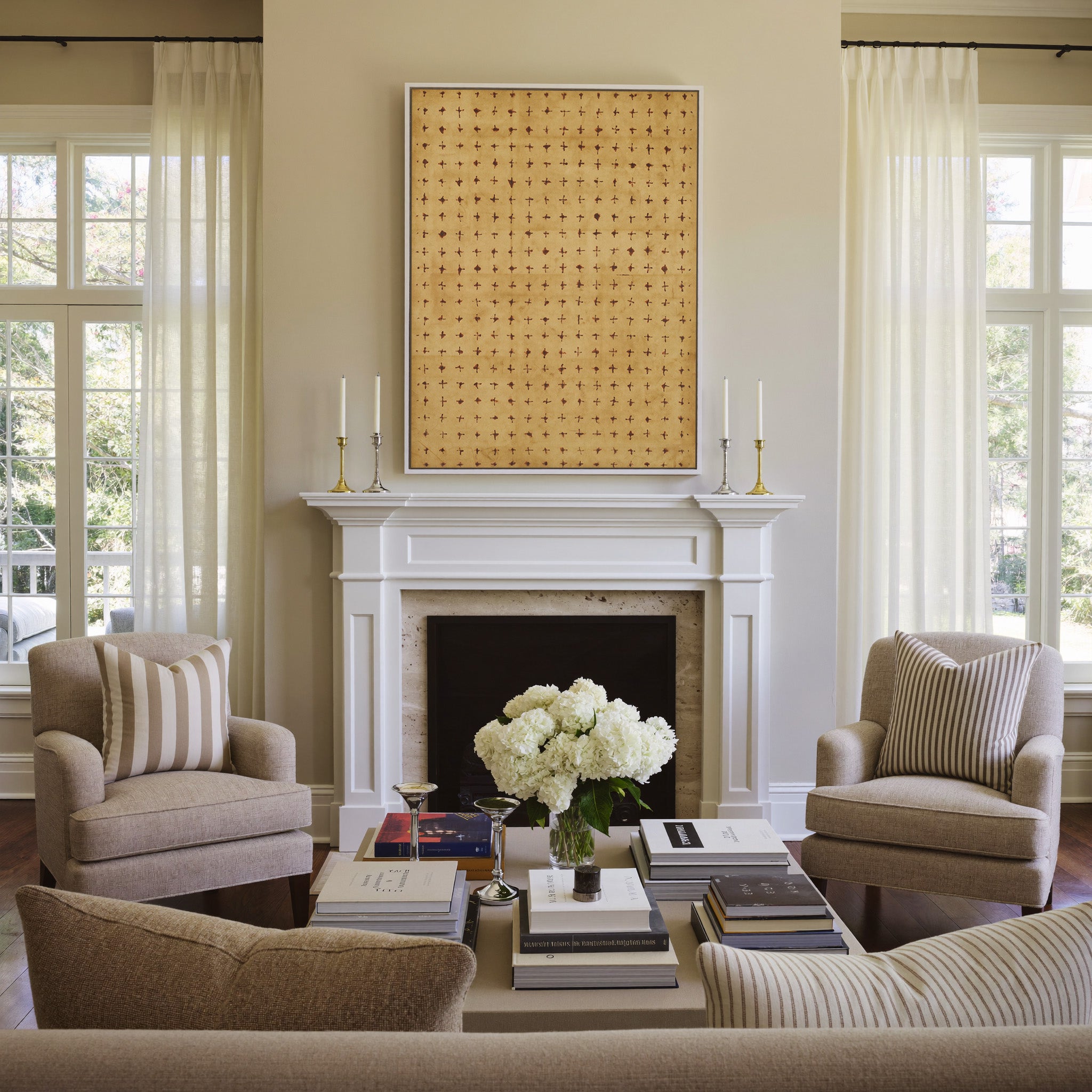 warm ochre abstract with small rust cross marks canvas wall art in a white frame above a mantel