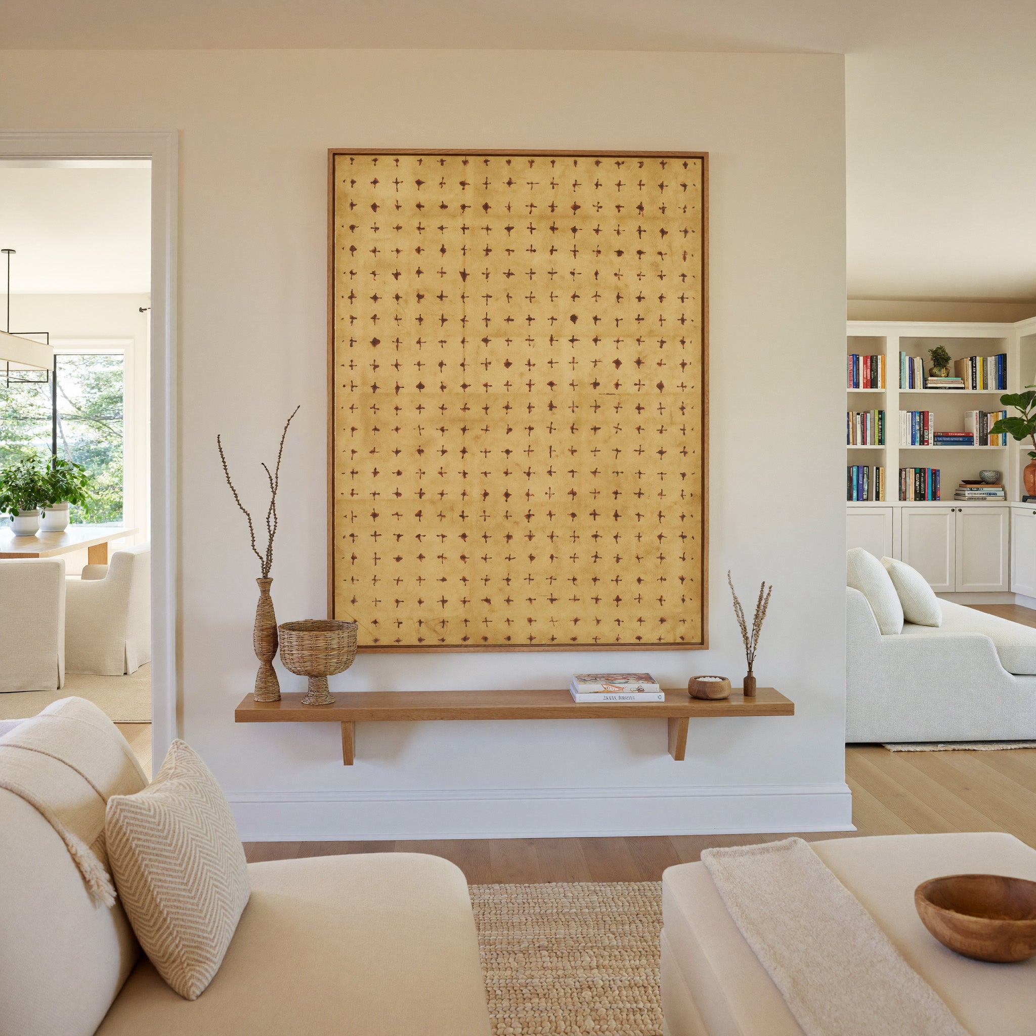 warm ochre abstract with small rust cross marks canvas wall art in an oak frame in a living room