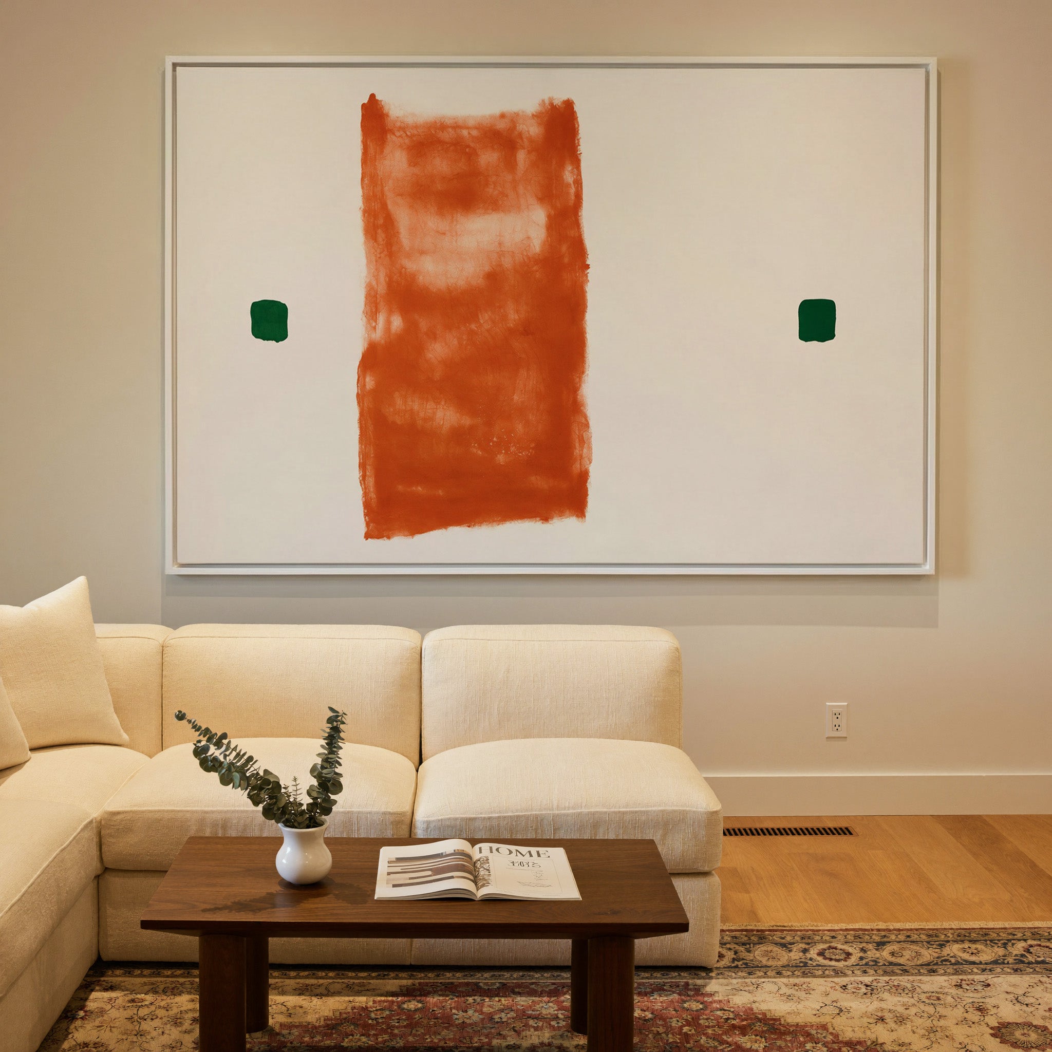 warm orange vertical block with two small green canvas wall art in a white frame in a styled room setting