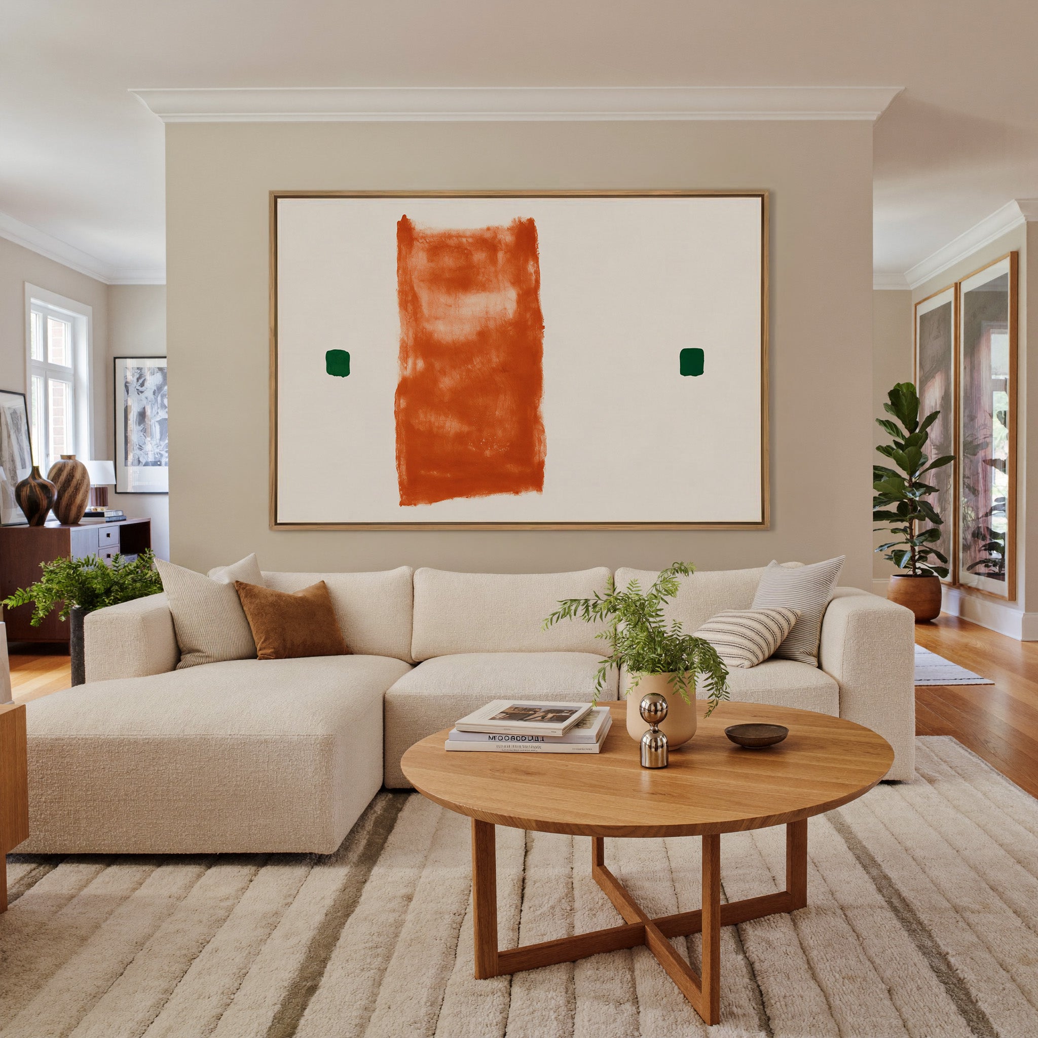 warm orange vertical block with two small green canvas wall art in an oak frame in a living room