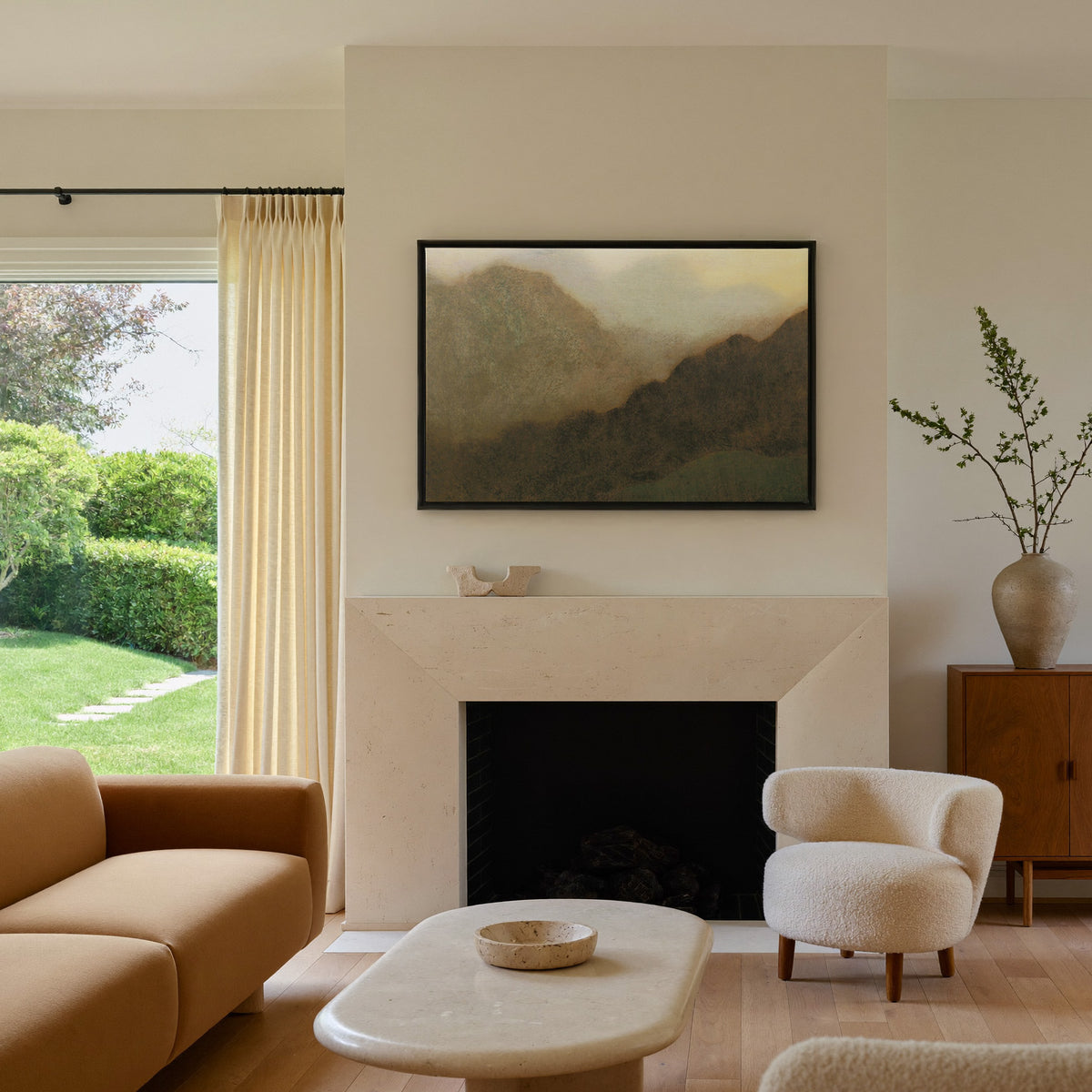 misty brown mountain landscape canvas wall art in a black frame above a mantel