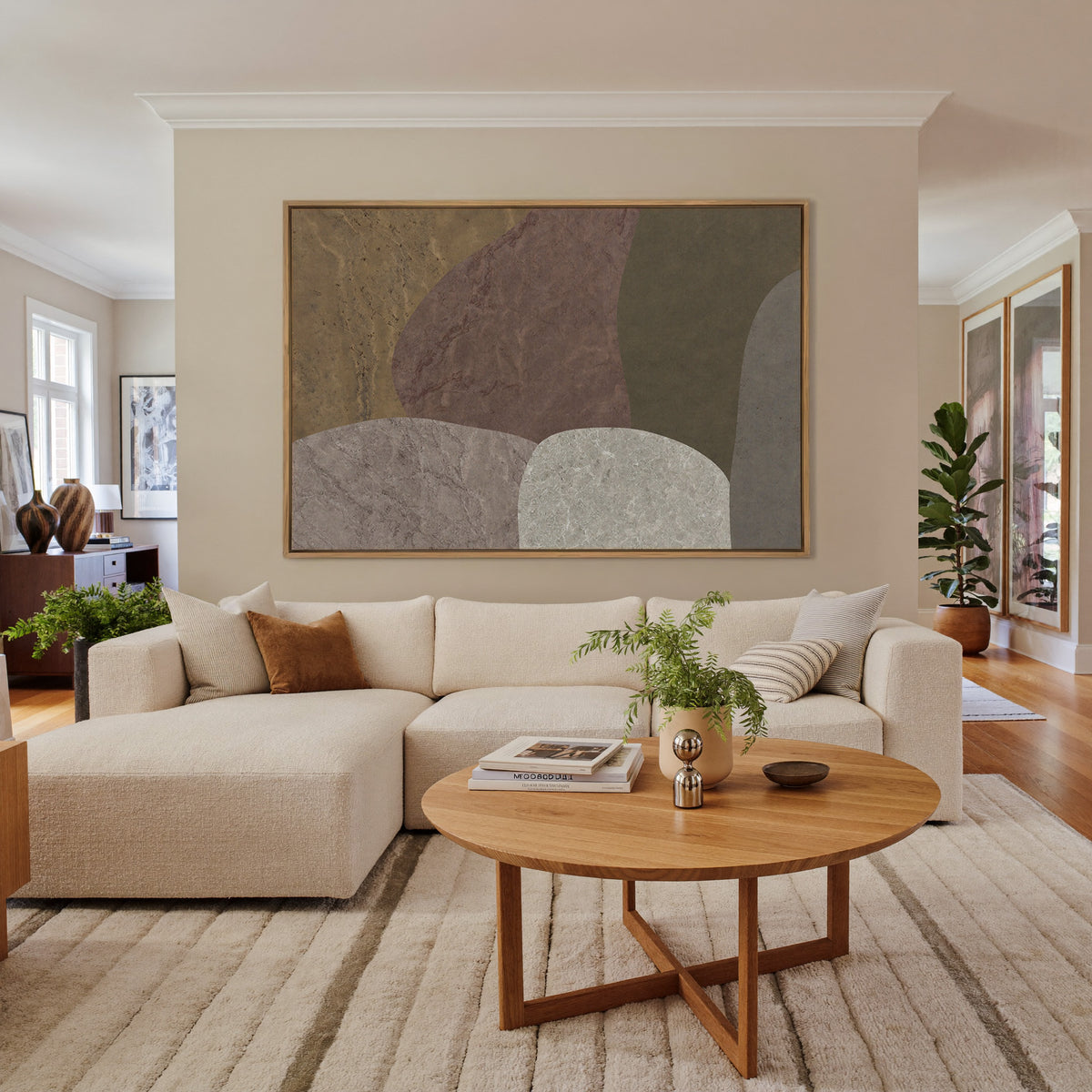 earthy abstract with arched stone like forms canvas wall art in an oak frame in a living room