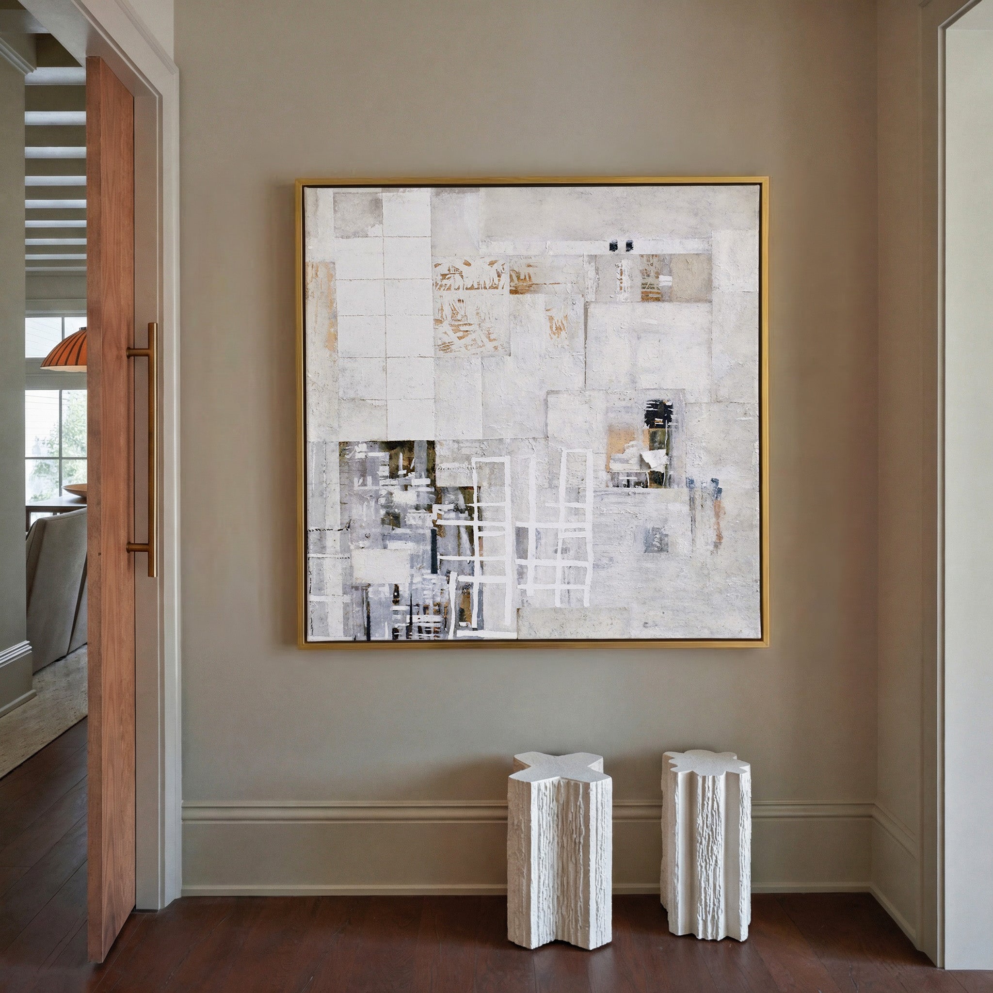 soft white and warm gray abstract with layered canvas wall art in a gold frame in a styled room setting