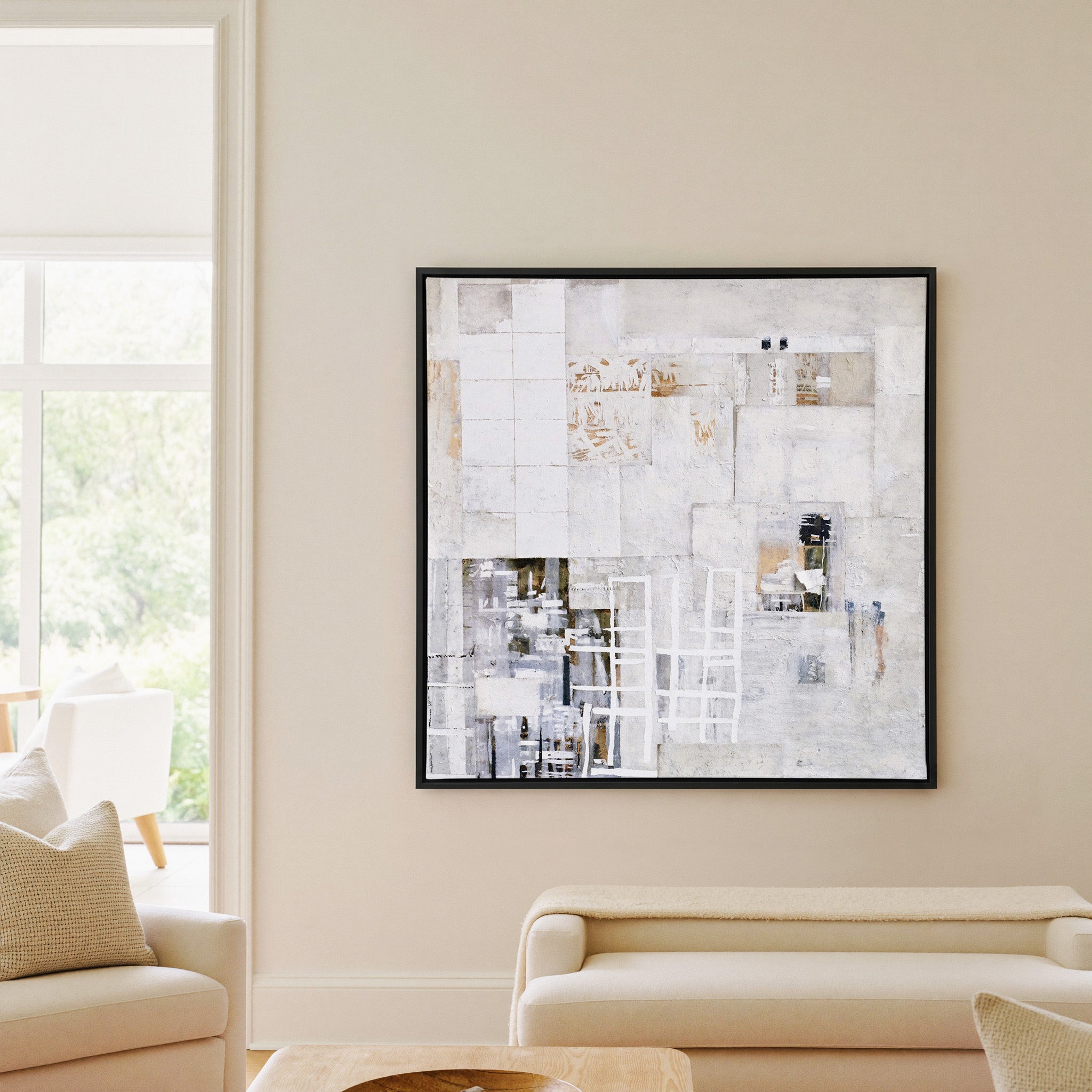 soft white and warm gray abstract with layered canvas wall art in a black frame in a living room