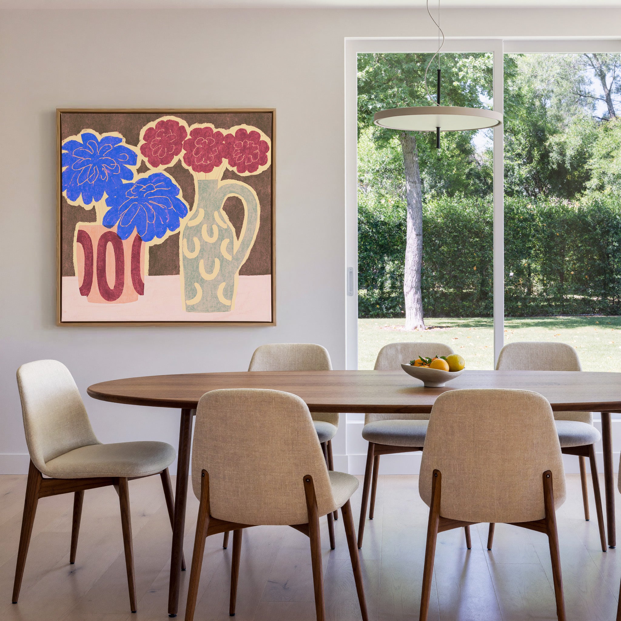 bold blue and burgundy flowers in patterned canvas wall art in an oak frame in a dining room