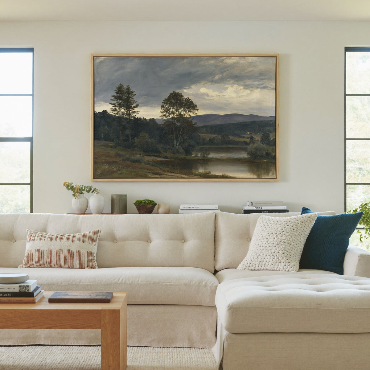 moody river landscape with trees and distant canvas wall art in a natural wood frame in a living room