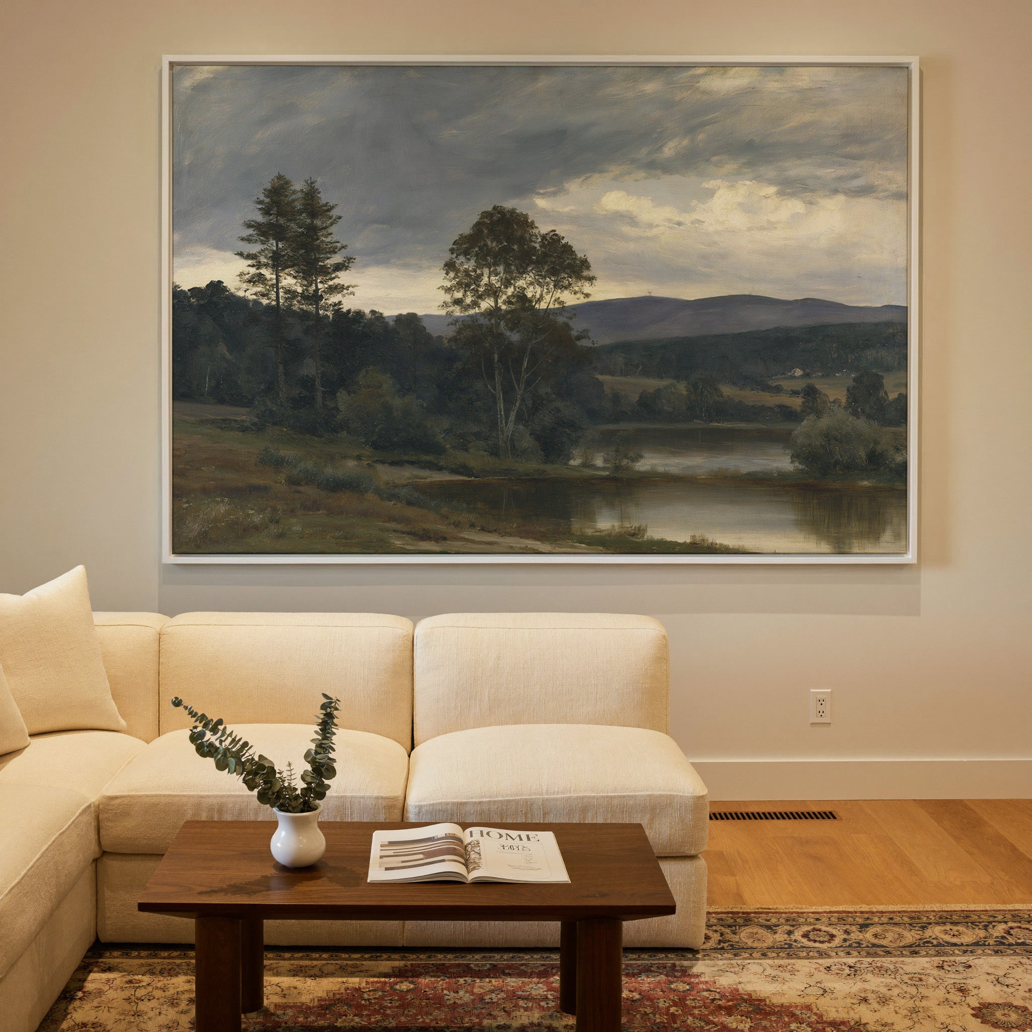 moody river landscape with trees and distant canvas wall art in a white frame in a styled room setting
