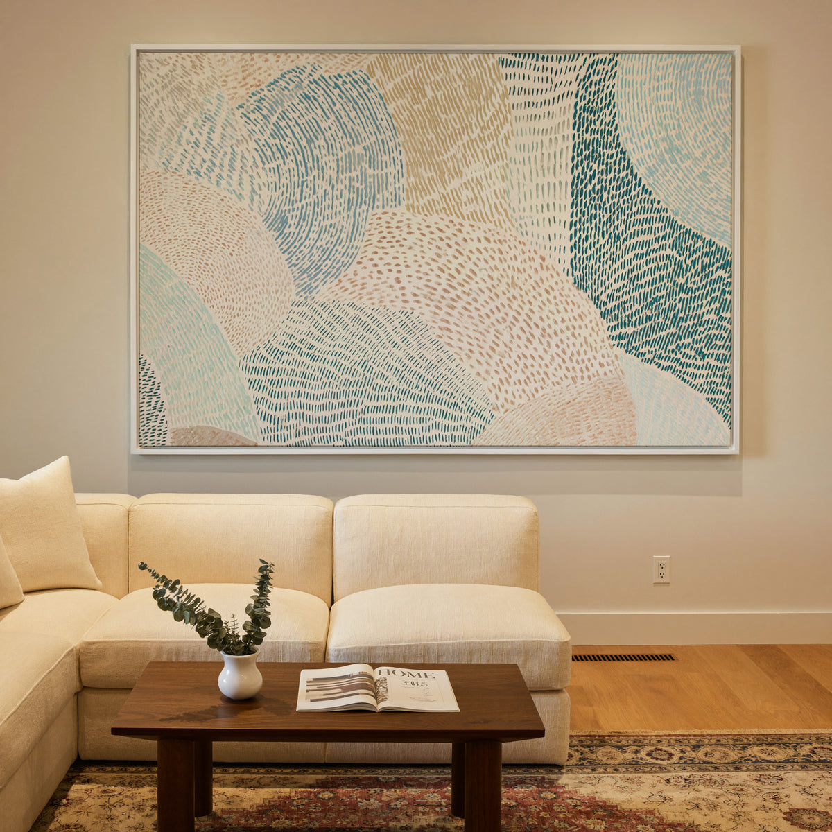soft coastal abstract with layered teal, aqua, canvas wall art in a white frame in a styled room setting