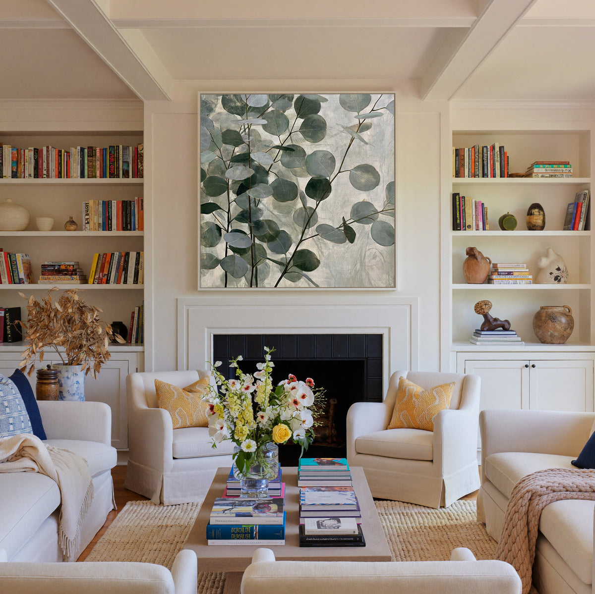layered eucalyptus branches with rounded blue canvas wall art in a white frame above a fireplace