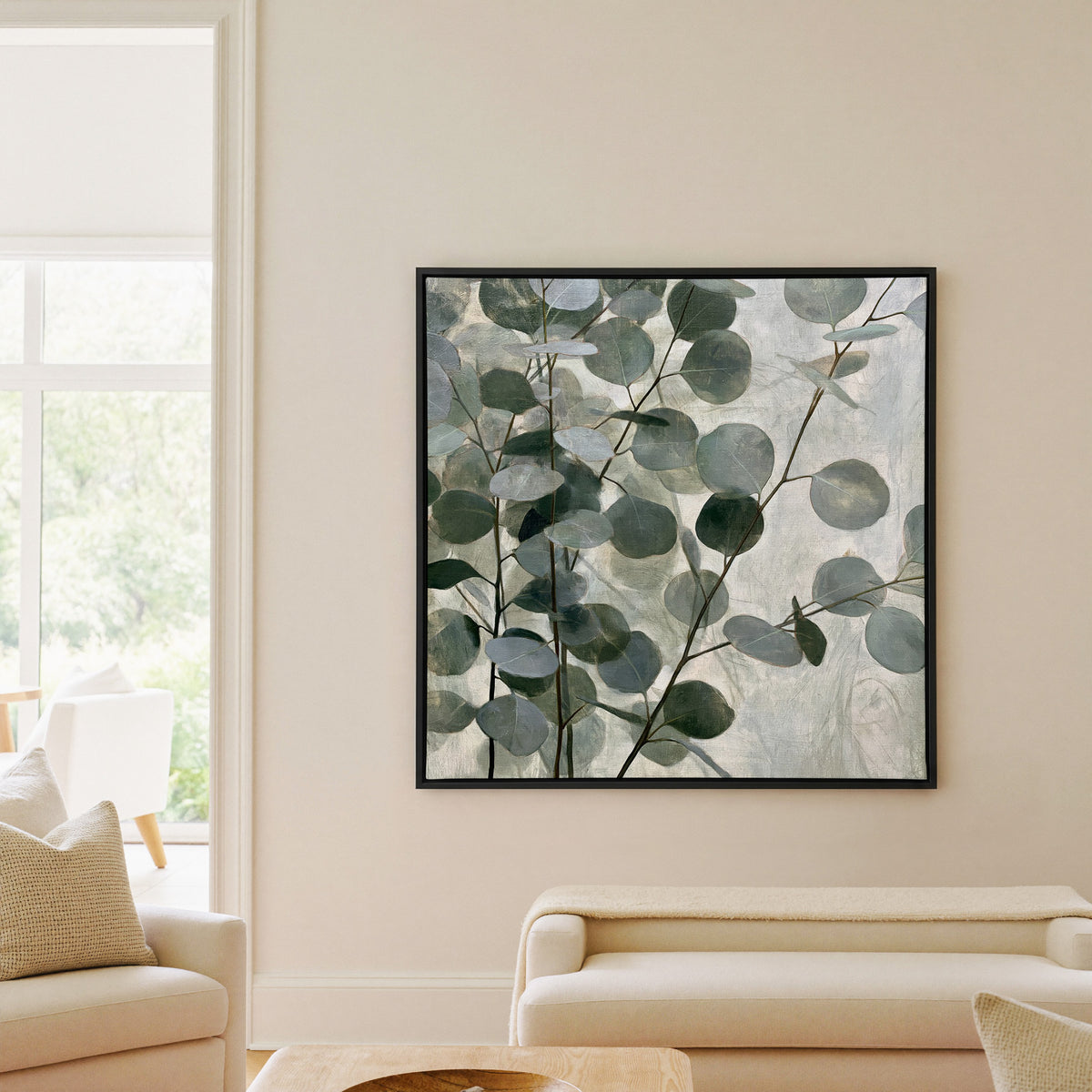 layered eucalyptus branches with rounded blue canvas wall art in a black frame in a living room