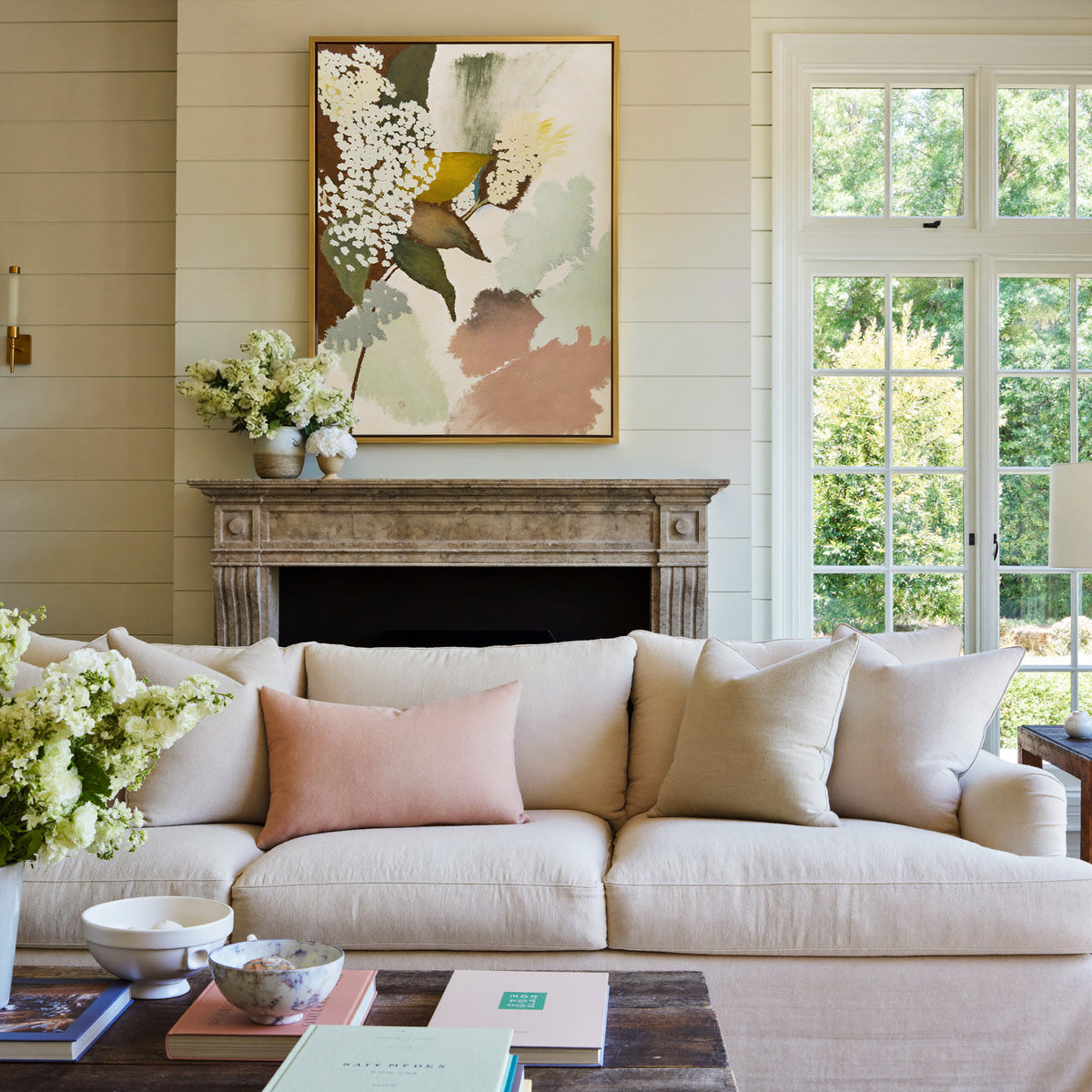 soft botanical abstract with pale green, blush, canvas wall art in a gold frame above a mantel