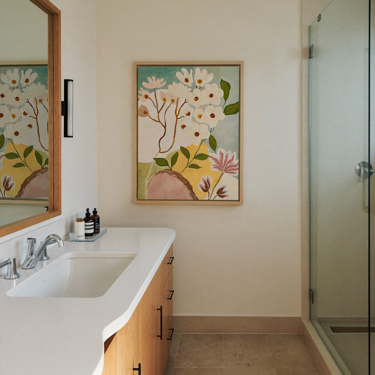 soft white blossoms with green canvas wall art in a natural wood frame in a styled room setting