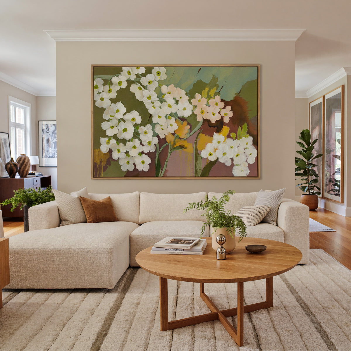 white and blush floral abstract with olive canvas wall art in an oak frame in a living room