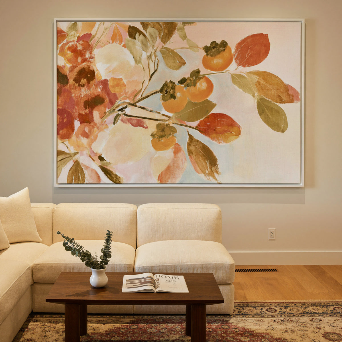 late autumn persimmon branches with orange canvas wall art in a white frame in a styled room setting