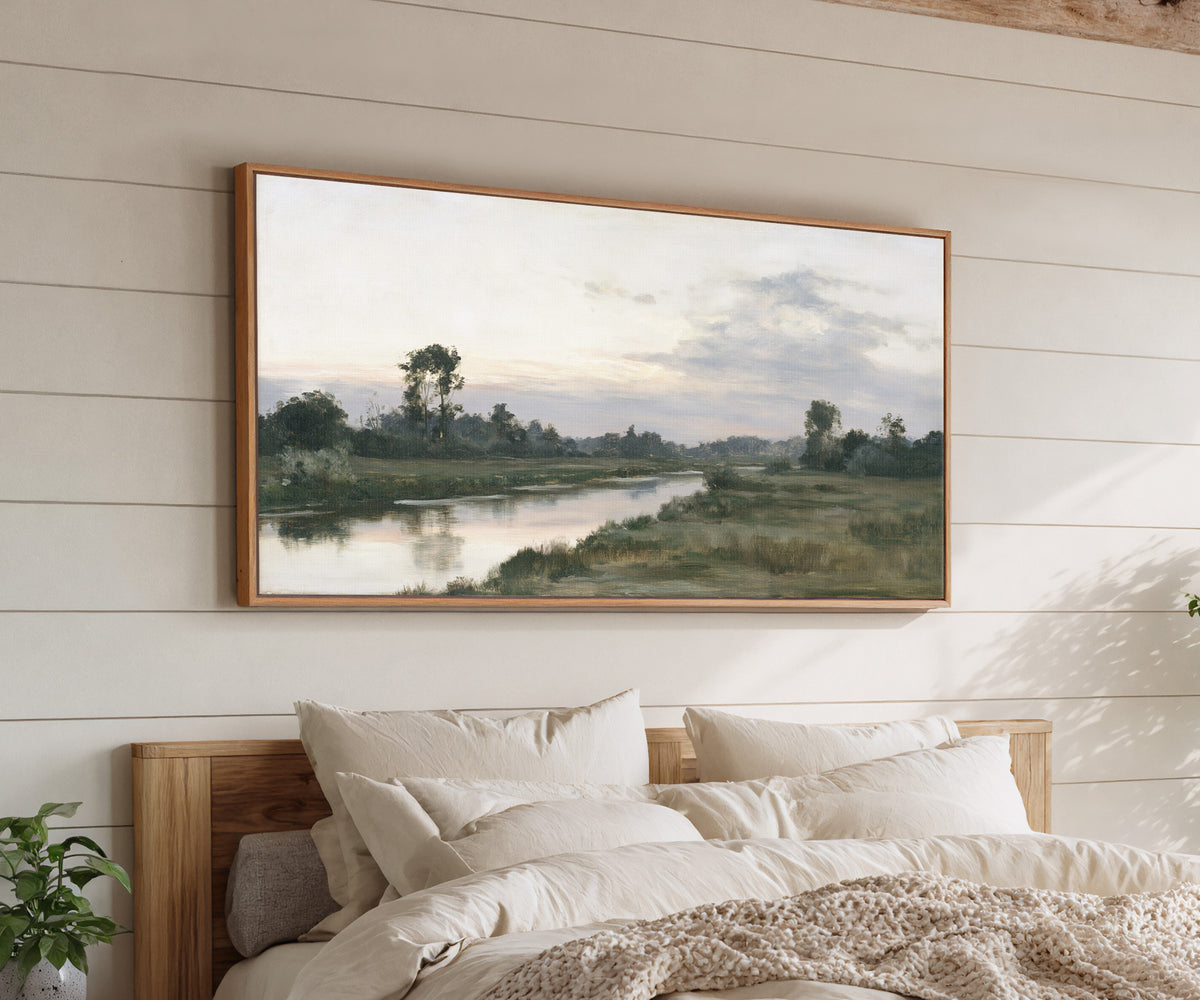 quiet river meadow at first light canvas wall art in an oak frame above a bed