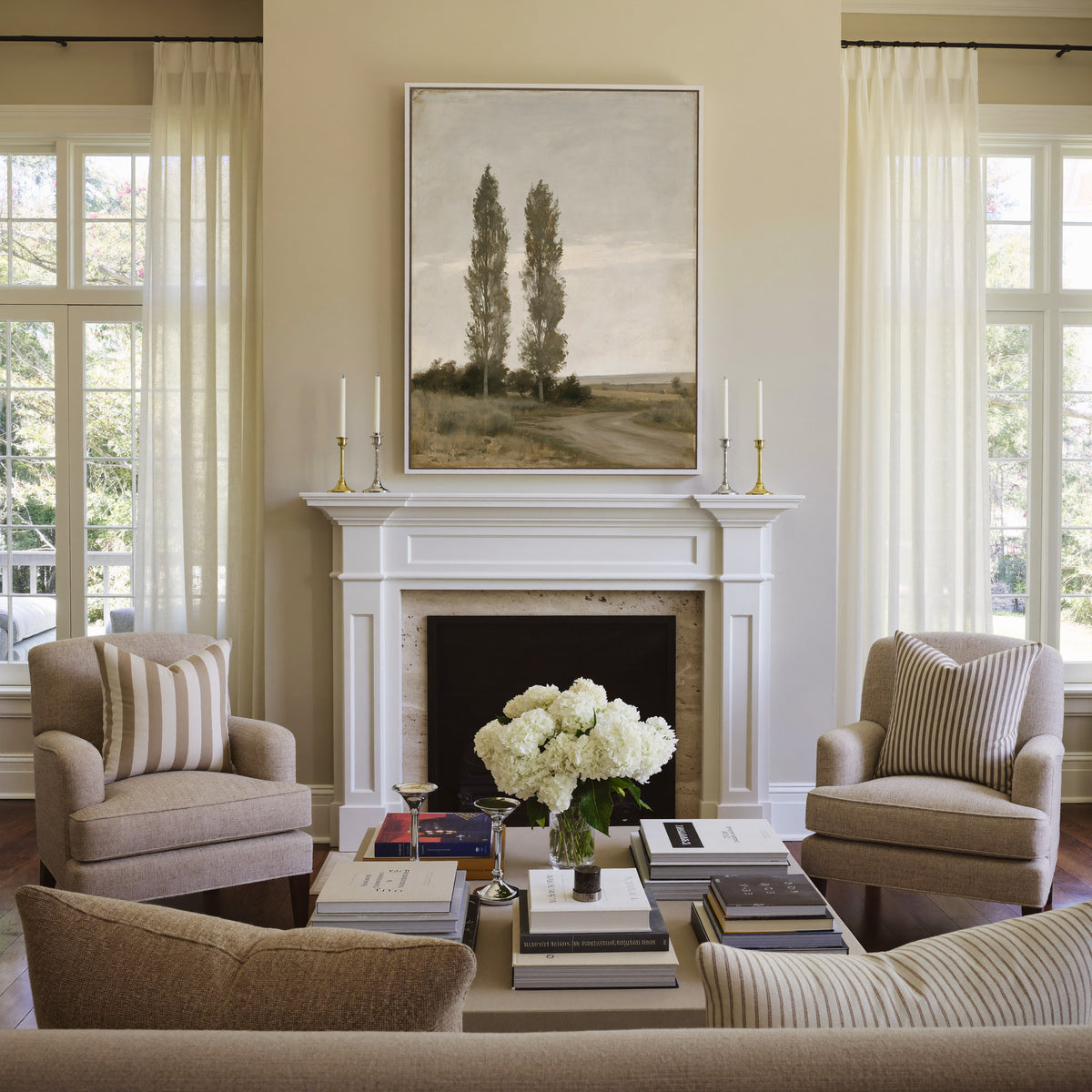 two slender poplar trees beside a curving dirt canvas wall art in a white frame above a mantel