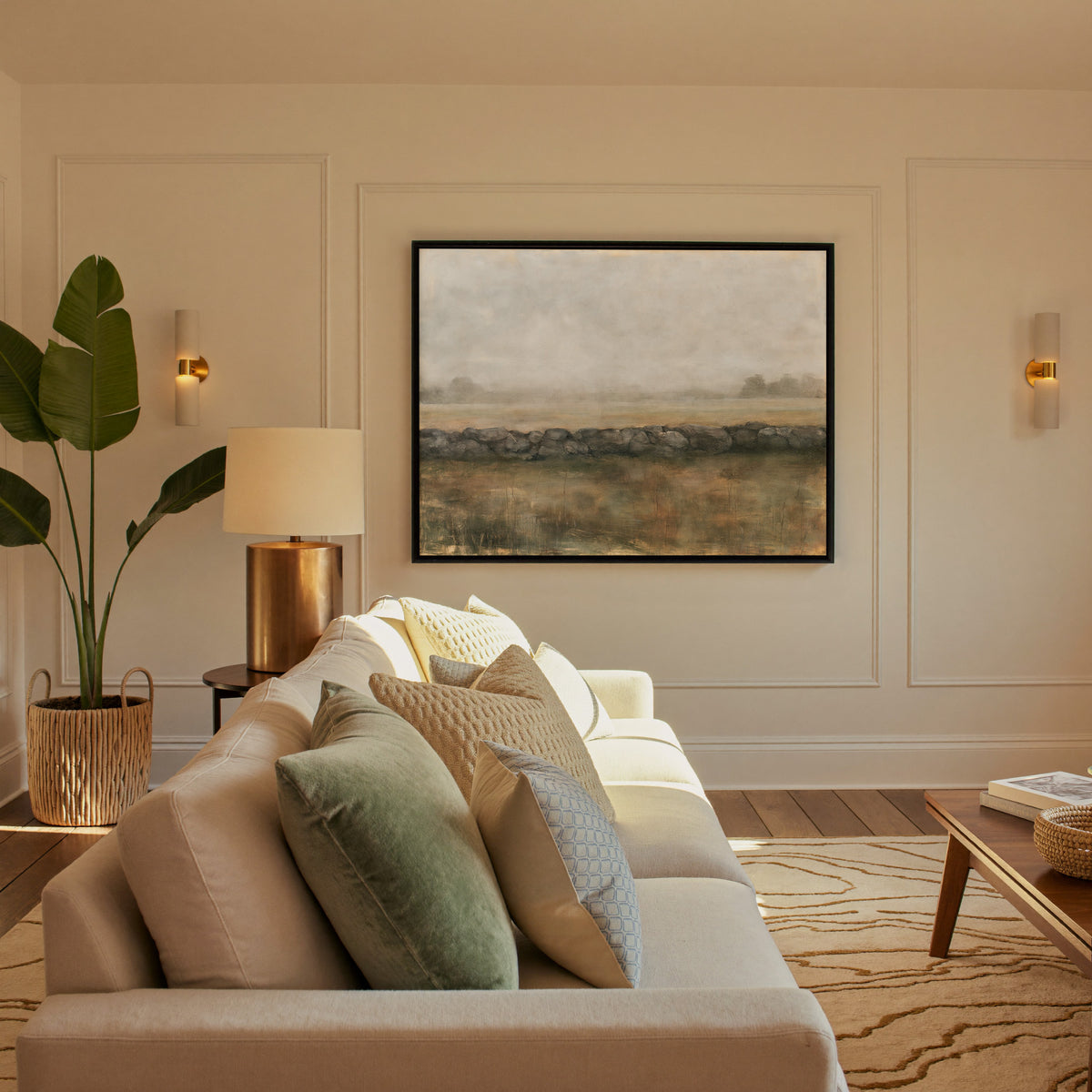 low stone wall across a hazy field canvas wall art in a black frame in a styled room setting