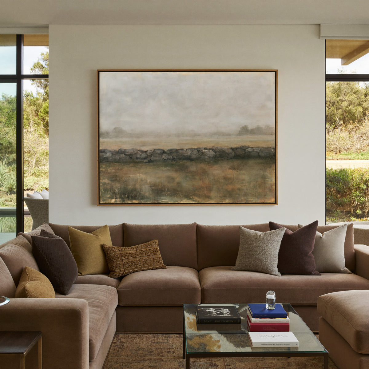 low stone wall across a hazy field canvas wall art in an oak frame in a styled room setting