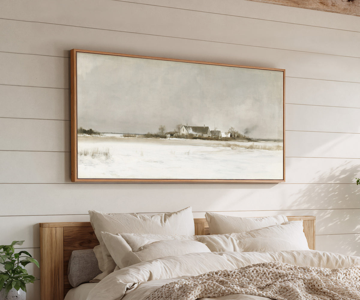 pale winter farmhouse landscape canvas wall art in an oak frame above a bed