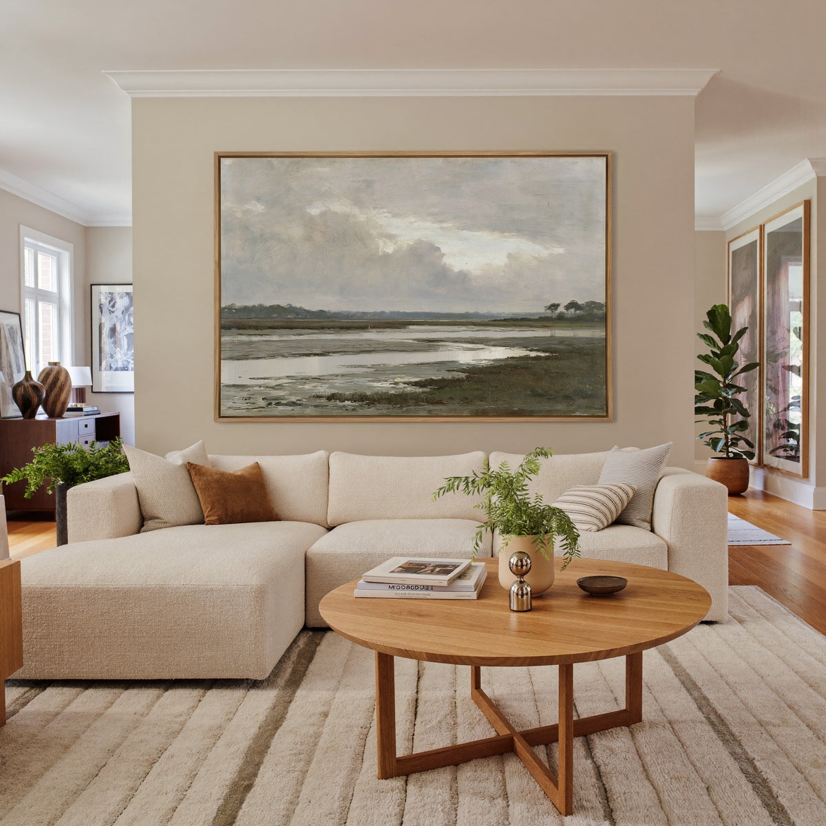 quiet inlet with mudflats and distant reed beds canvas wall art in an oak frame in a living room