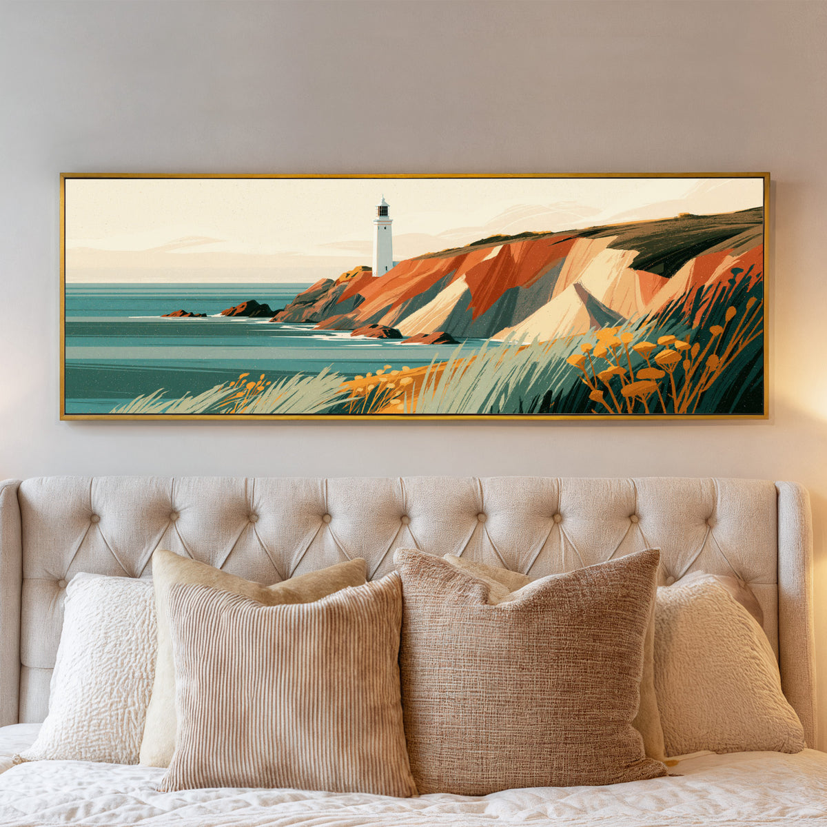 white lighthouse above rust colored cliffs and canvas wall art in a gold floater frame above a bed