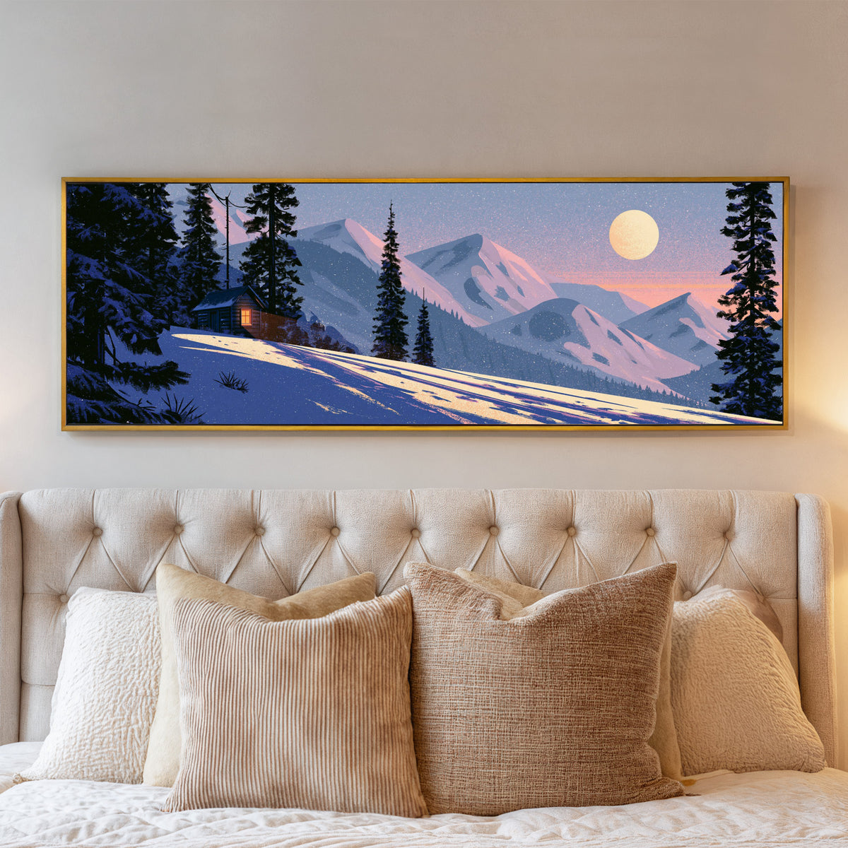 snowbound cabin beneath pink mountain ridges canvas wall art in a gold floater frame above a bed