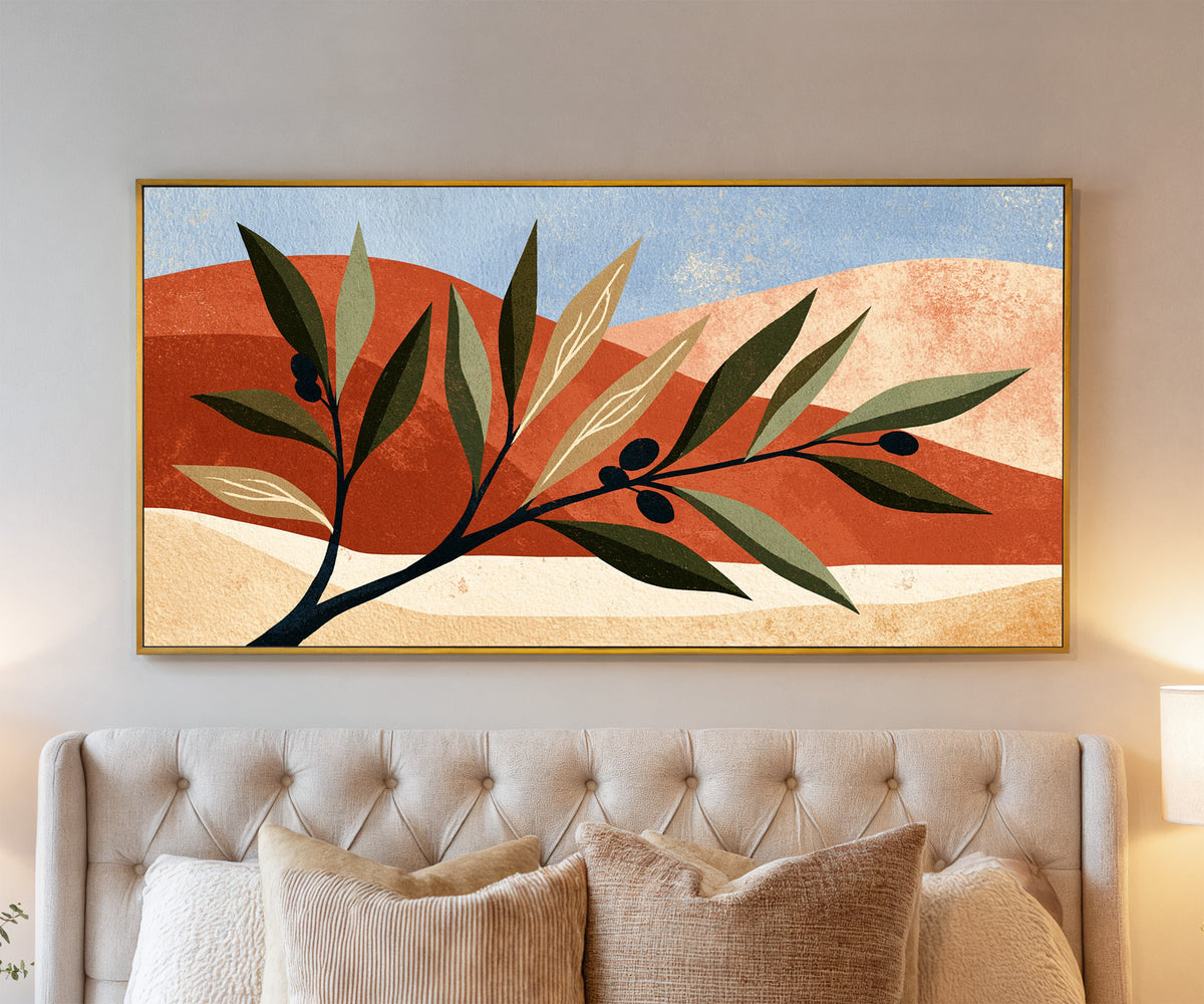 olive branch against terracotta curves and pale canvas wall art in a gold floater frame above a bed
