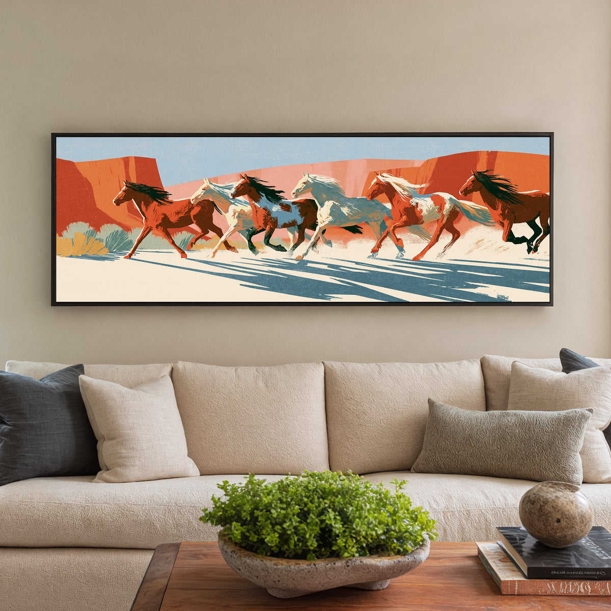 running horse herd beneath terracotta cliffs canvas wall art in a black floater frame in a styled room setting