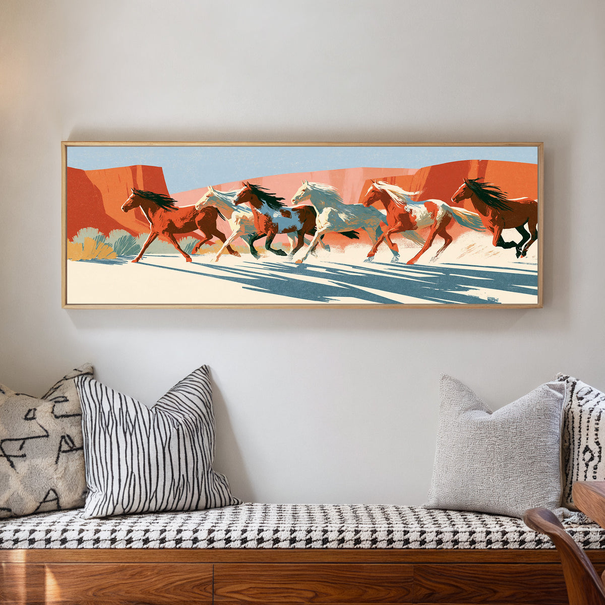 running horse herd beneath terracotta cliffs canvas wall art in a natural floater frame in a living room
