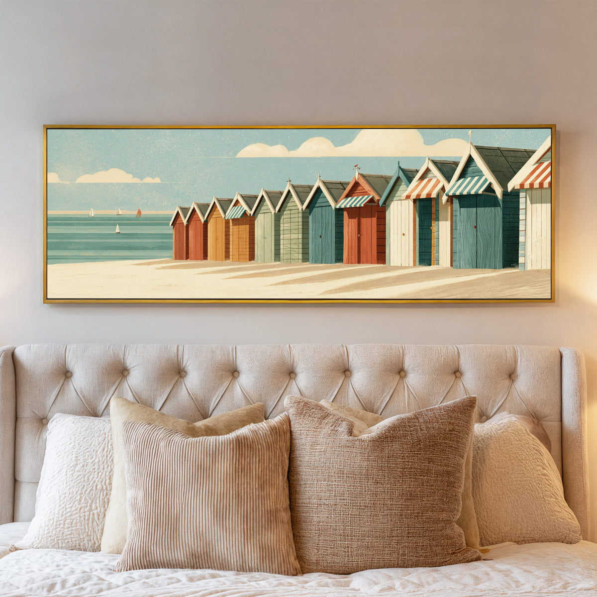 receding beach huts with striped awnings beside canvas wall art in a gold floater frame above a bed