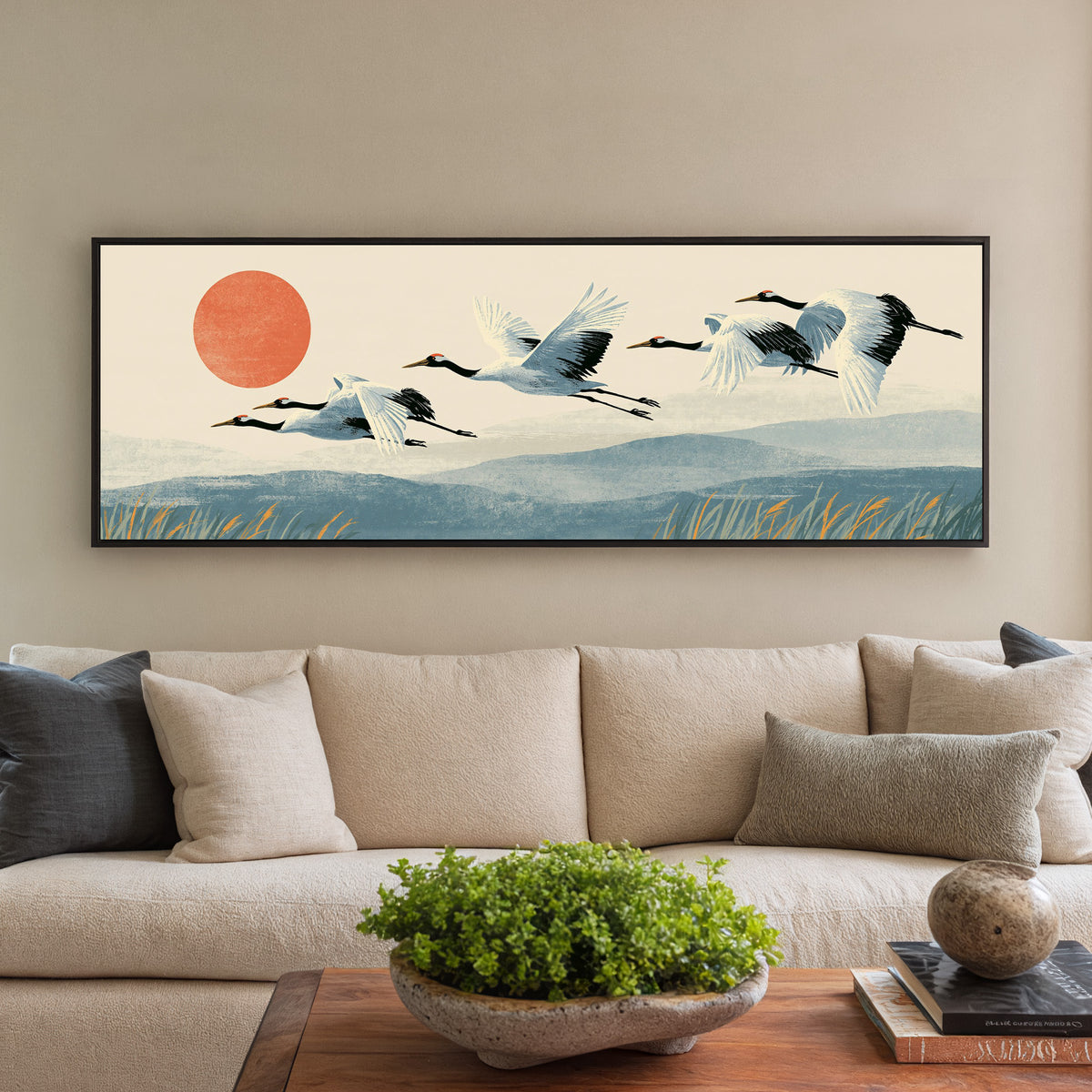 red crowned cranes flying over blue hills canvas wall art in a black floater frame in a styled room setting