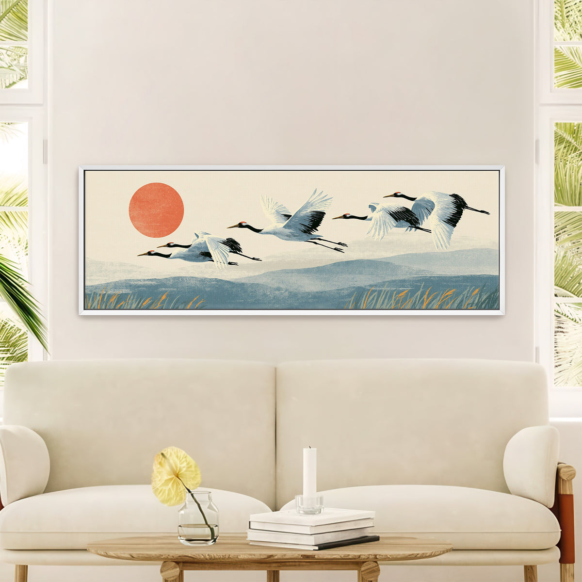 red crowned cranes flying over blue hills canvas wall art in a white floater frame in a styled room setting