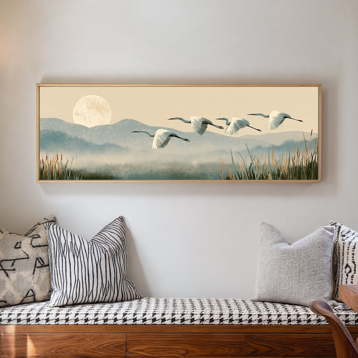 four white egrets flying above misty blue hills canvas wall art in a natural floater frame in a living room
