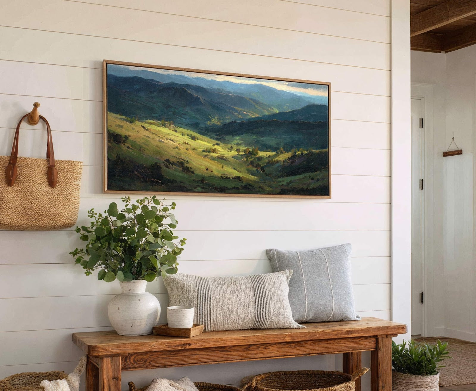 This horizontal canvas wall art features an Impressionistic landscape of verdant hills and distant mountains, rendered in a palette of greens and blues. It hangs on a white shiplap wall.